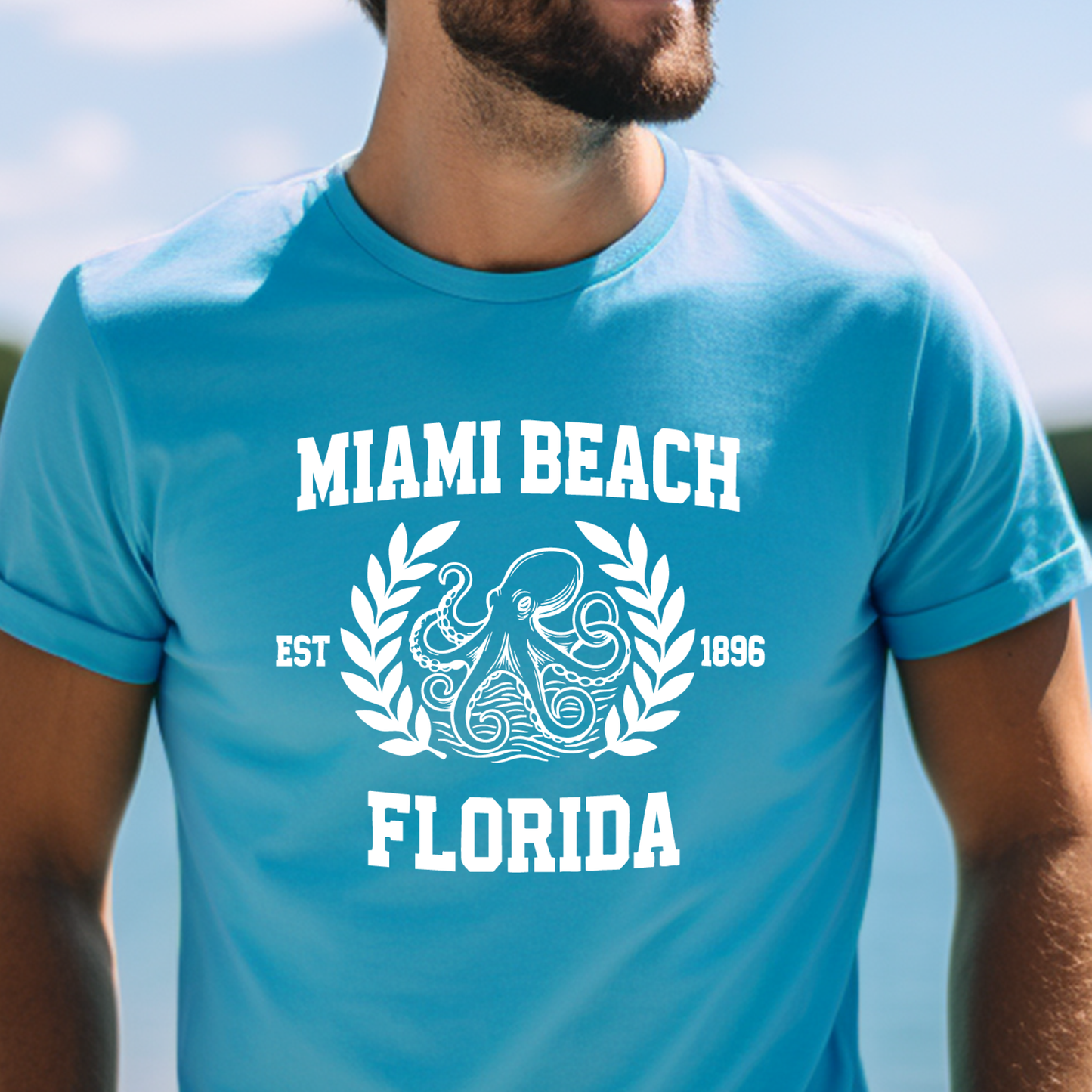 Person wearing a aqua blue t-shirt with 'Miami Beach Florida' design.