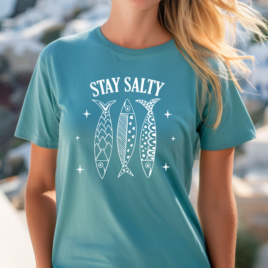 Person wearing a turquoise t-shirt with 'Stay Salty' and fish illustrations.