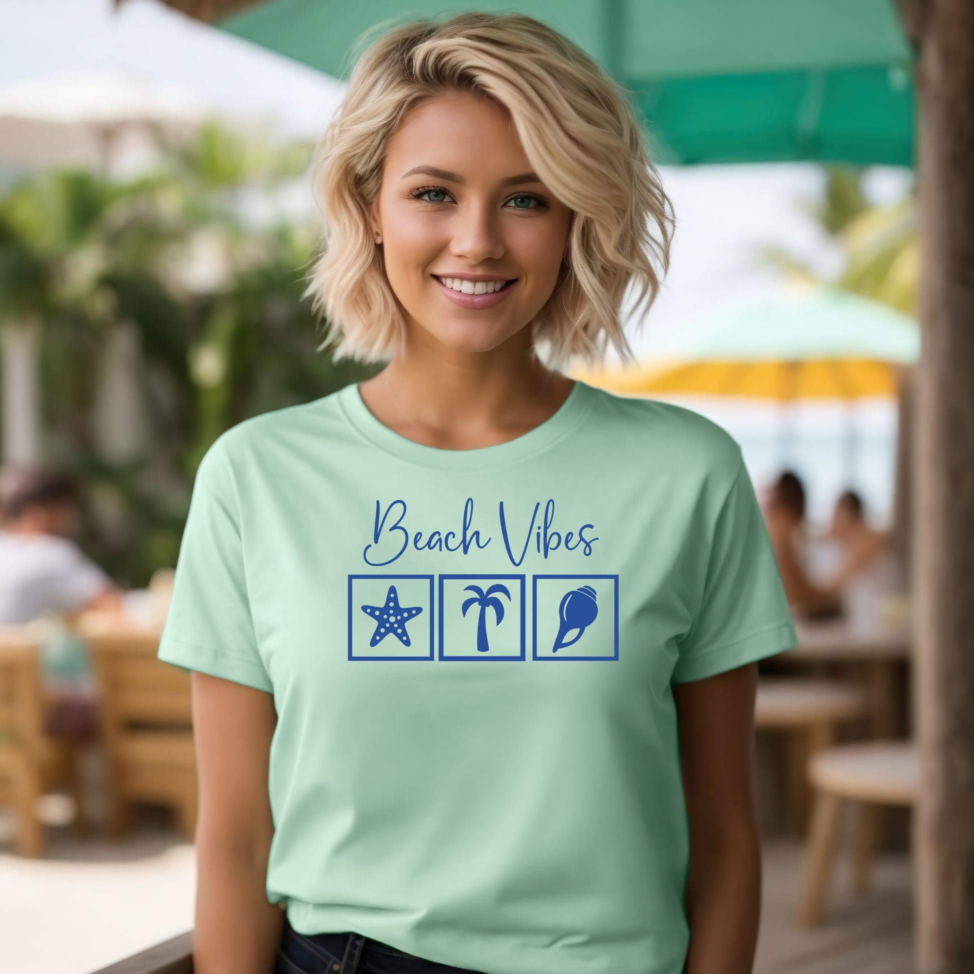 Bella and Canvas 3001 "Beach Vibes" t shirt with a starfish, palm tree, and a seashell graphics in monochrome color. Picture of a girl standing in a beach bar wearing a t shirt.