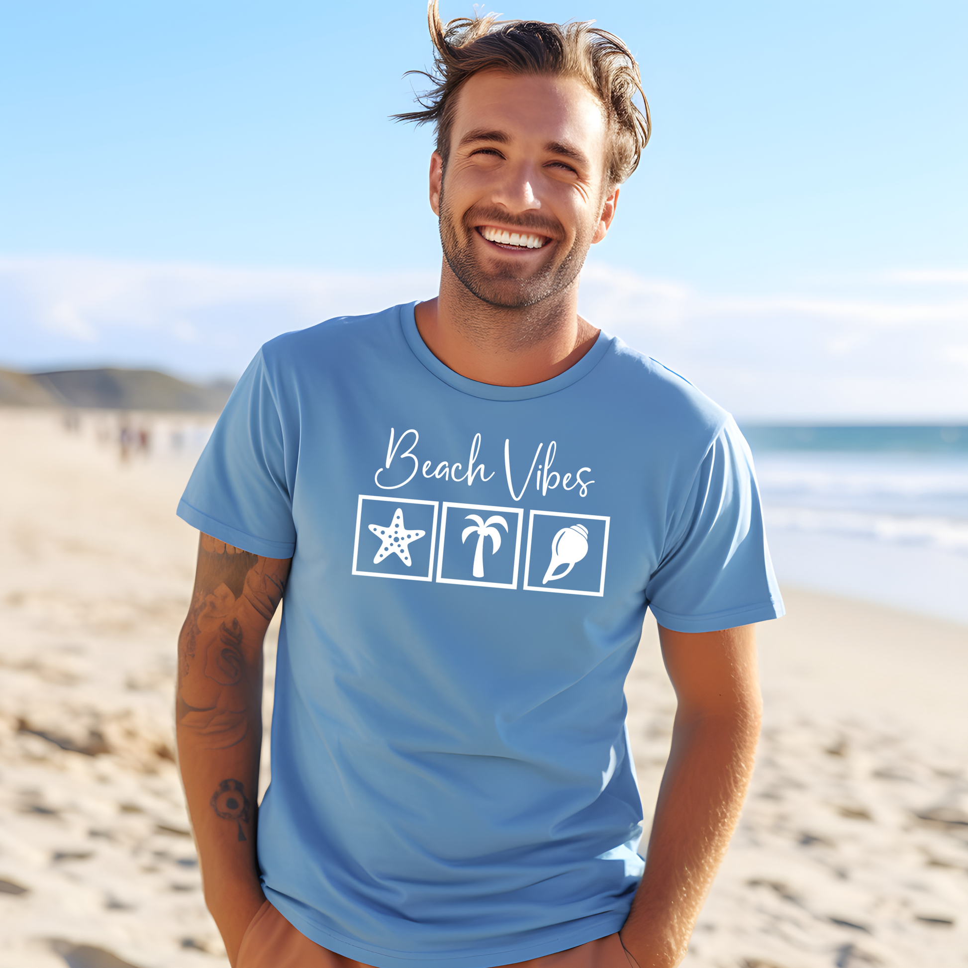 Bella and Canvas 3001 "Beach Vibes" t shirt with a starfish, palm tree, and a seashell graphics in monochrome color. Picture of a man standing on the beach wearing a t shirt.