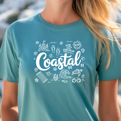 Person wearing a turquoise t-shirt with 'Coastal' design featuring beach elements.