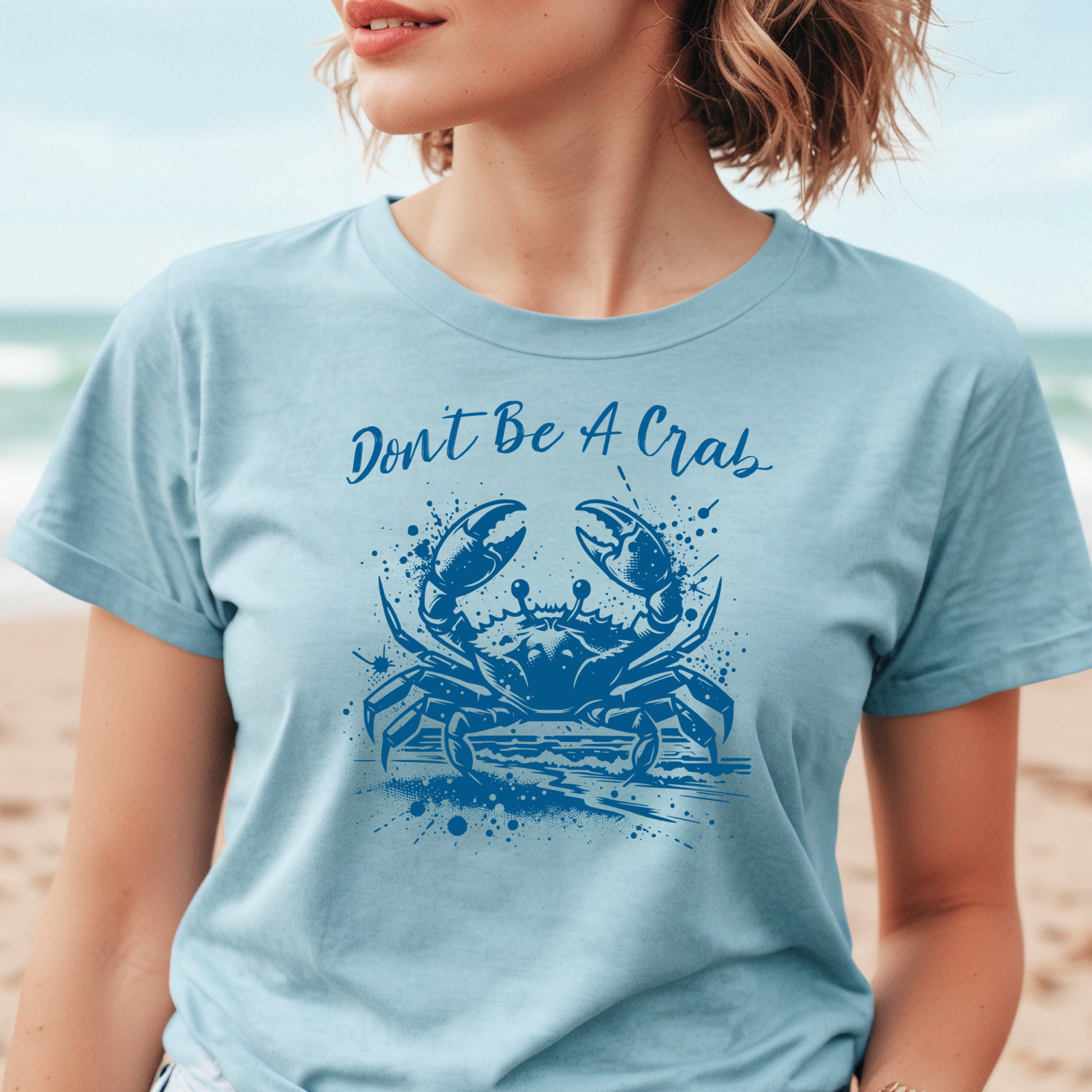 Bella and Canvas 3001 "Don't Be A Crab" t shirt with crab splashing in water one color graphic. Picture of a girl standing on the beach wearing a t shirt.