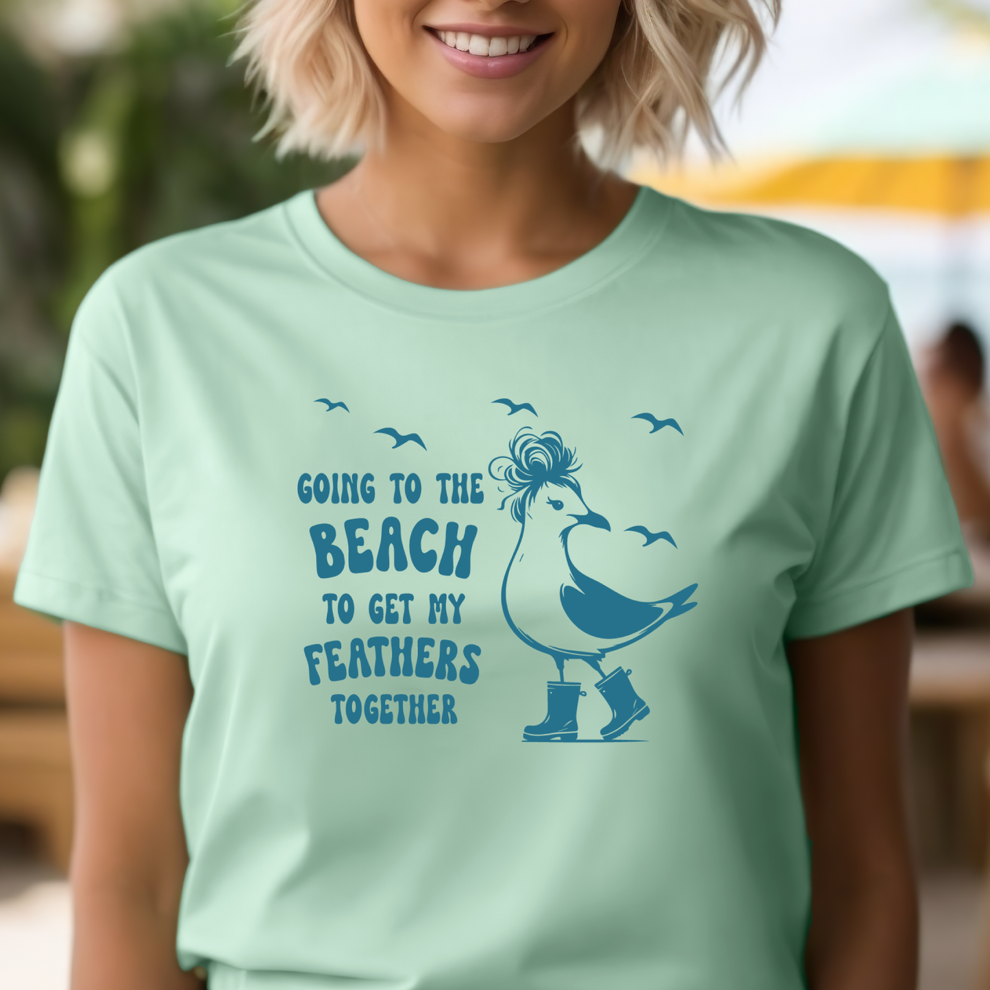 Person wearing a light green t-shirt with a blue graphic and text.