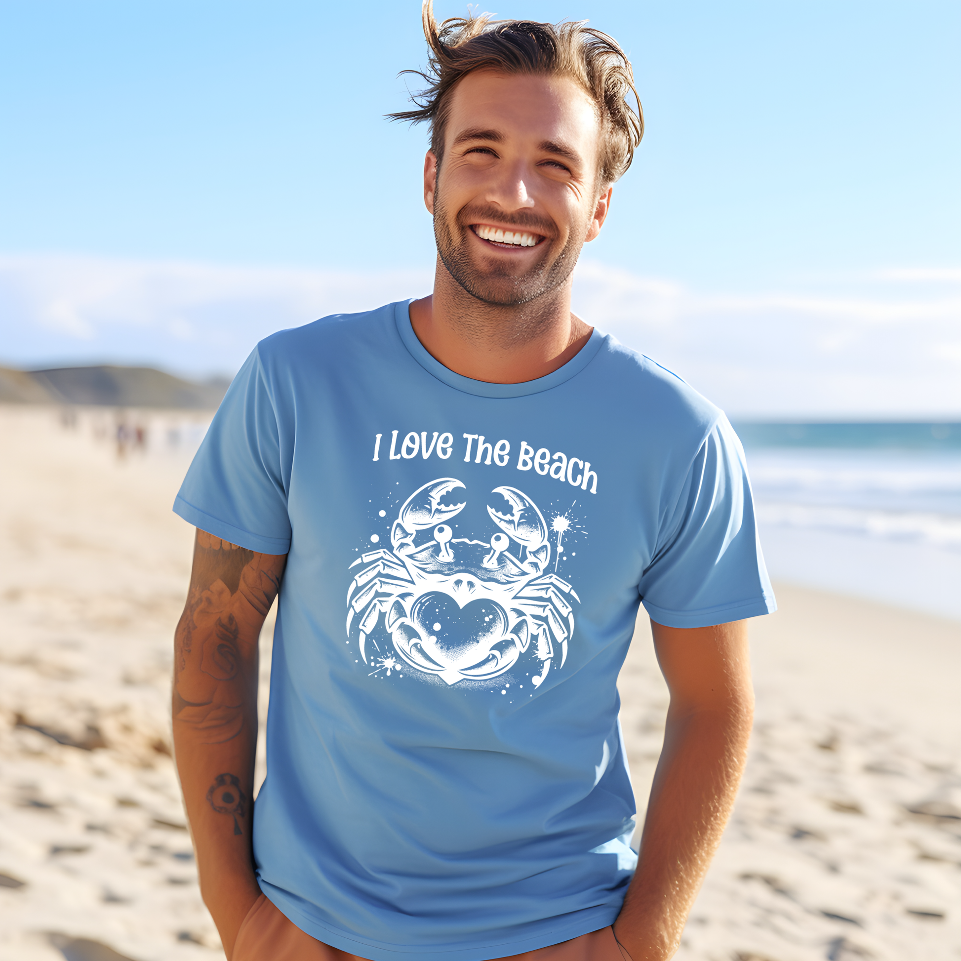 Bella Canvas 3001 "I Love The Beach" t shirt with a crab holding a heart one color graphic. Picture of a man standing on the beach wearing a t shirt.