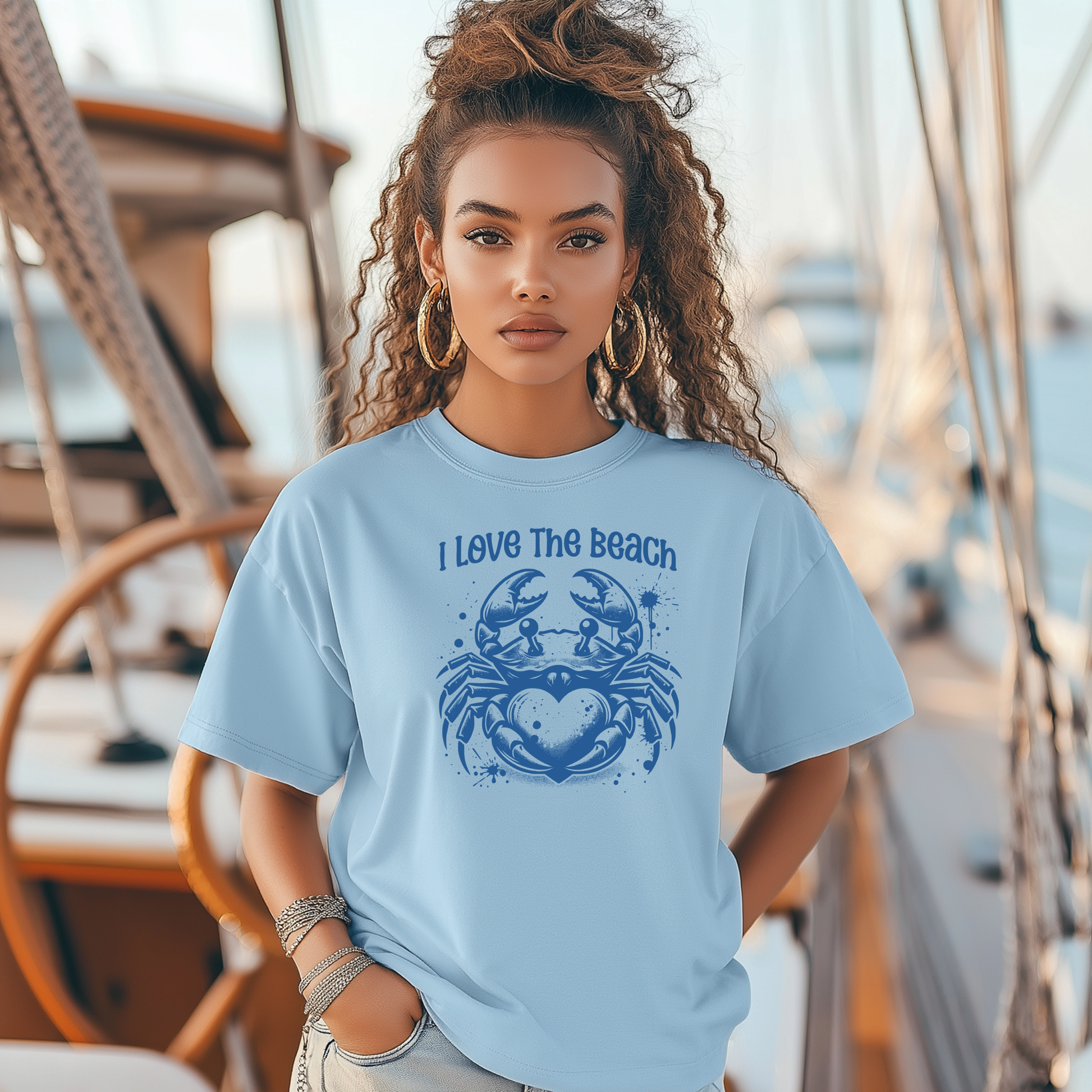 Bella Canvas 3001 "I Love The Beach" t shirt with a crab holding a heart one color graphic. Picture of a girl standing on a boat wearing a t shirt.