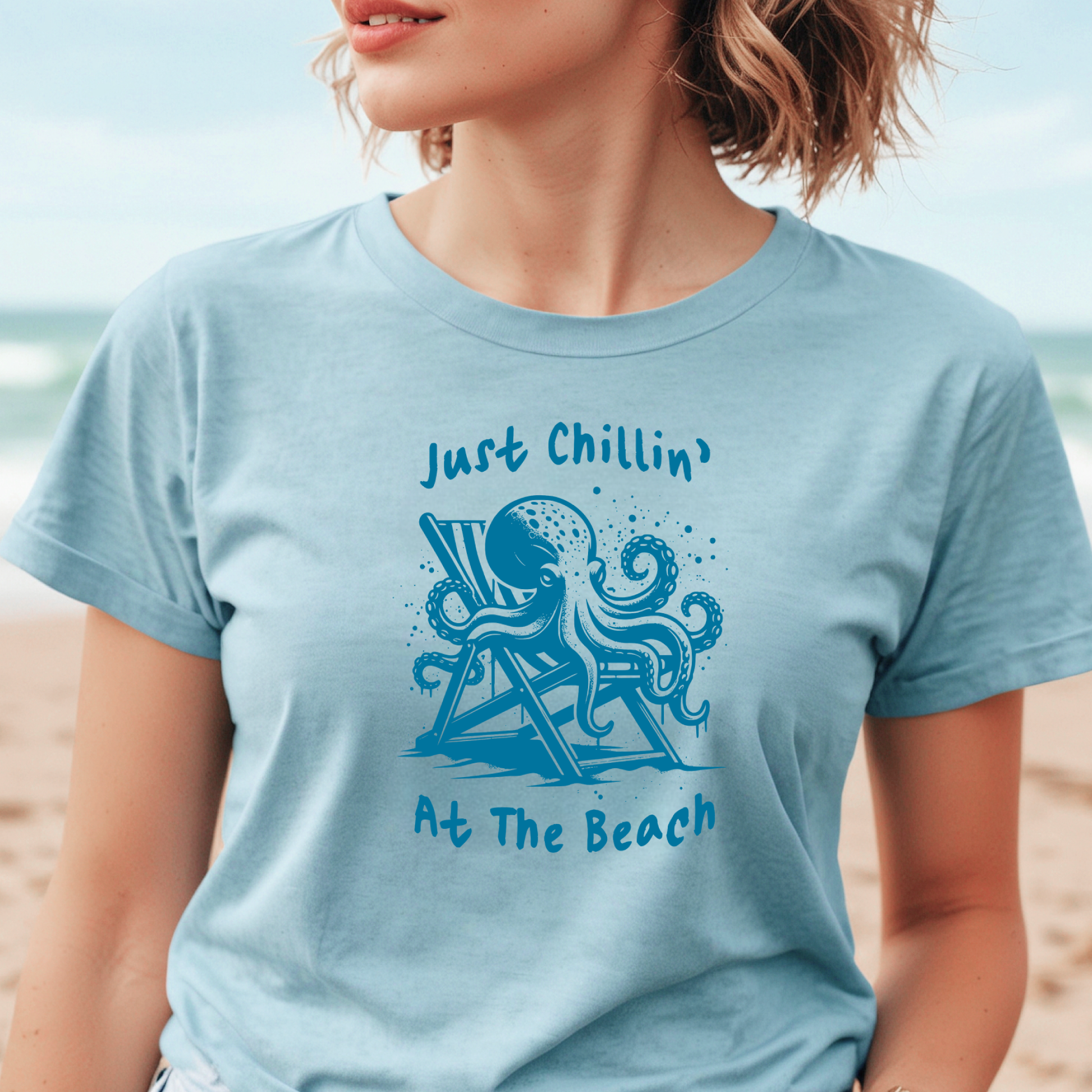 Bella Canvas 3001 "Just Chillin' At The Beach" t shirt with an octopus lounging in a beach chair in a one color graphic. Picture of a girl standing on the beach wearing a t shirt.