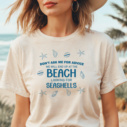 Person wearing a t-shirt with beach-themed text and graphics at a beach.