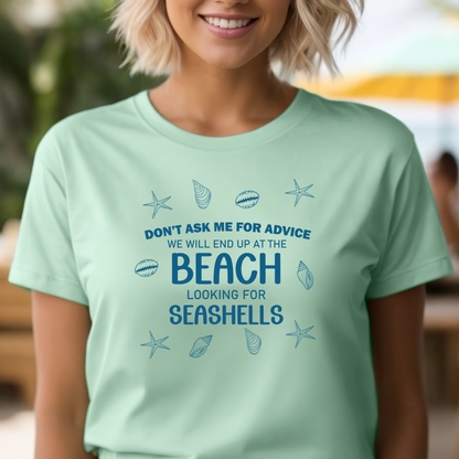 Person wearing a light green t-shirt with beach-themed text and graphics.