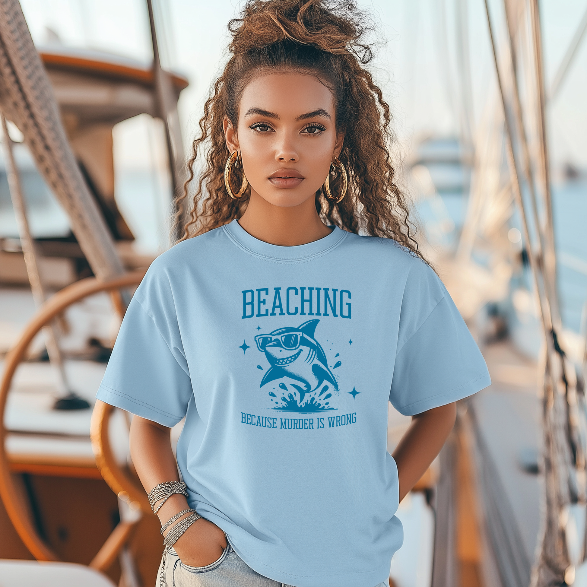 Bella Canvas 3001 Beaching Because Murder Is Wrong  T Shirt with Funny Shark with Sunglasses splashing in water in one color graphic. Picture of a girl standing on a boat wearing a t shirt.