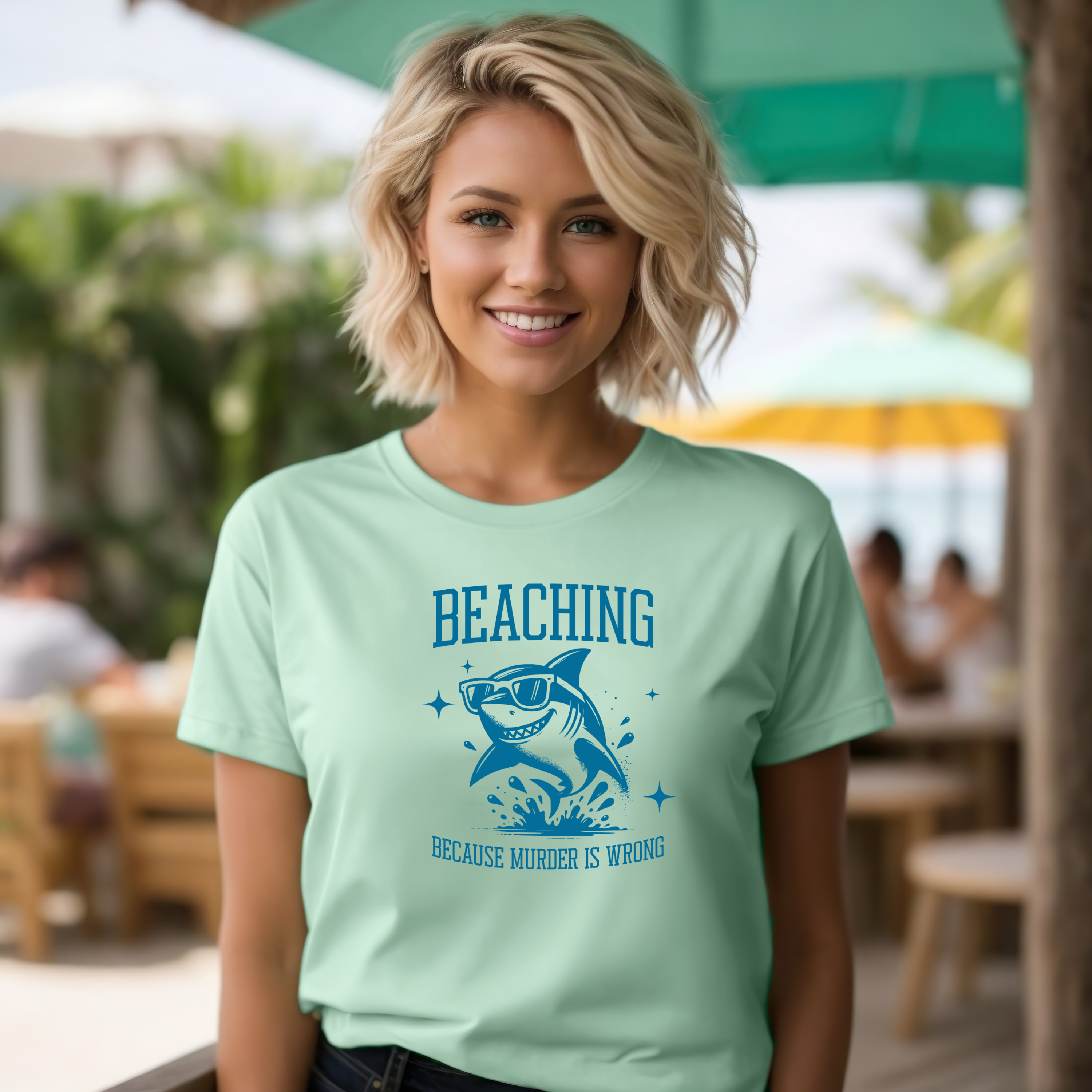 Bella Canvas 3001 Beaching Because Murder Is Wrong  T Shirt with Funny Shark with Sunglasses splashing in water in one color graphic. Picture of a girl standing in a beach bar wearing a t shirt.