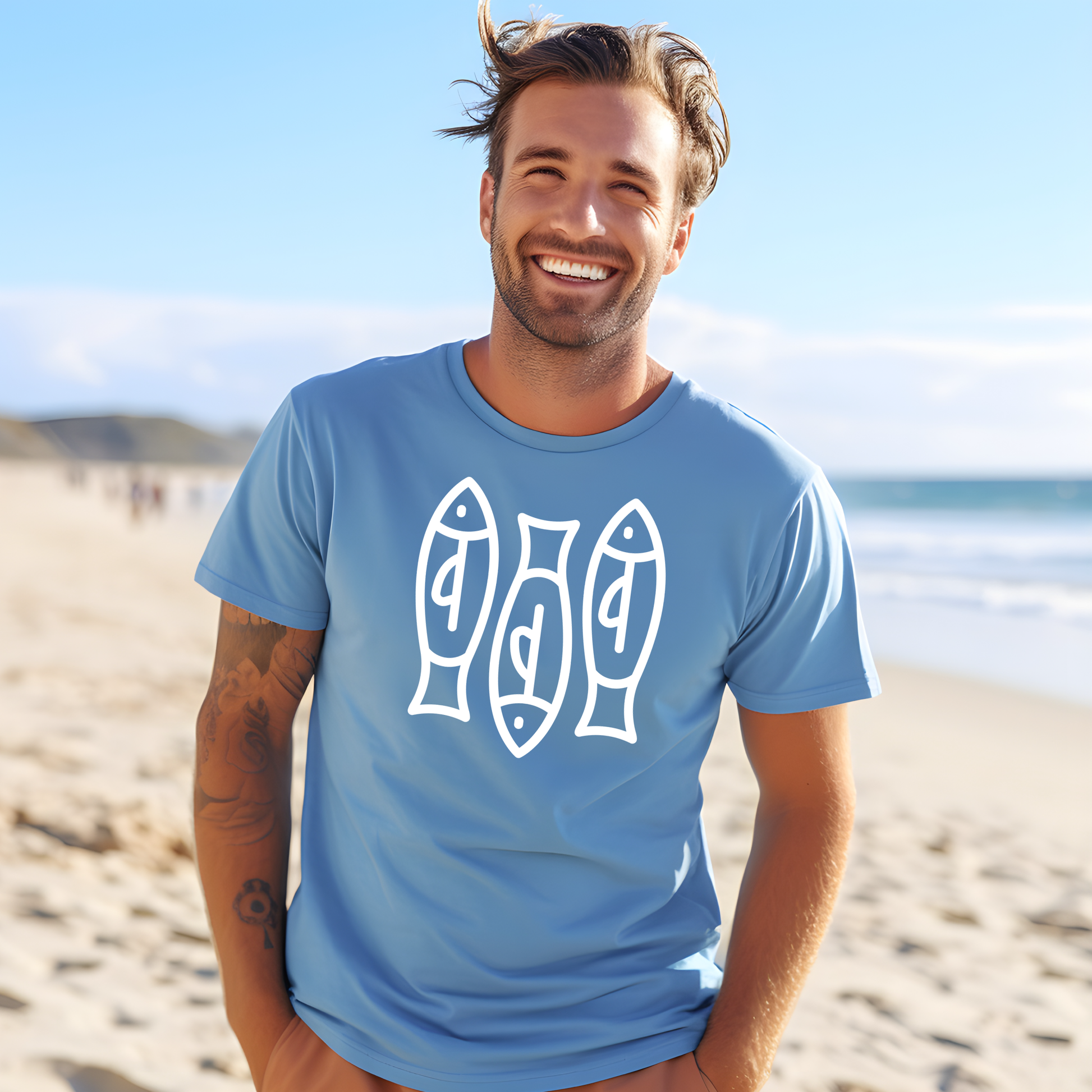 Bella canvas t shirt of a monoline art of  three sardines in one color graphic. Picture of a man standing on the beach wearing a t shirt.