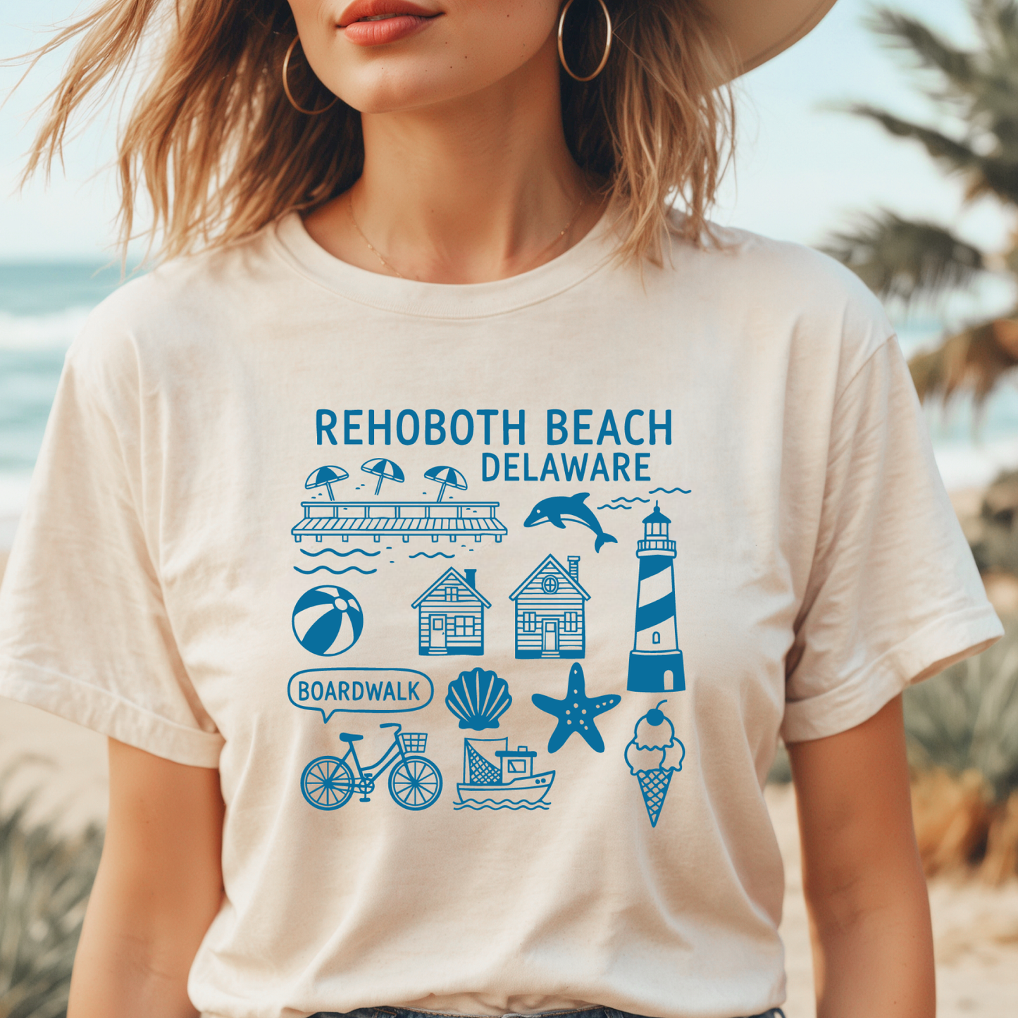 Person wearing a t-shirt with Rehoboth Beach, Delaware graphics on a beach.