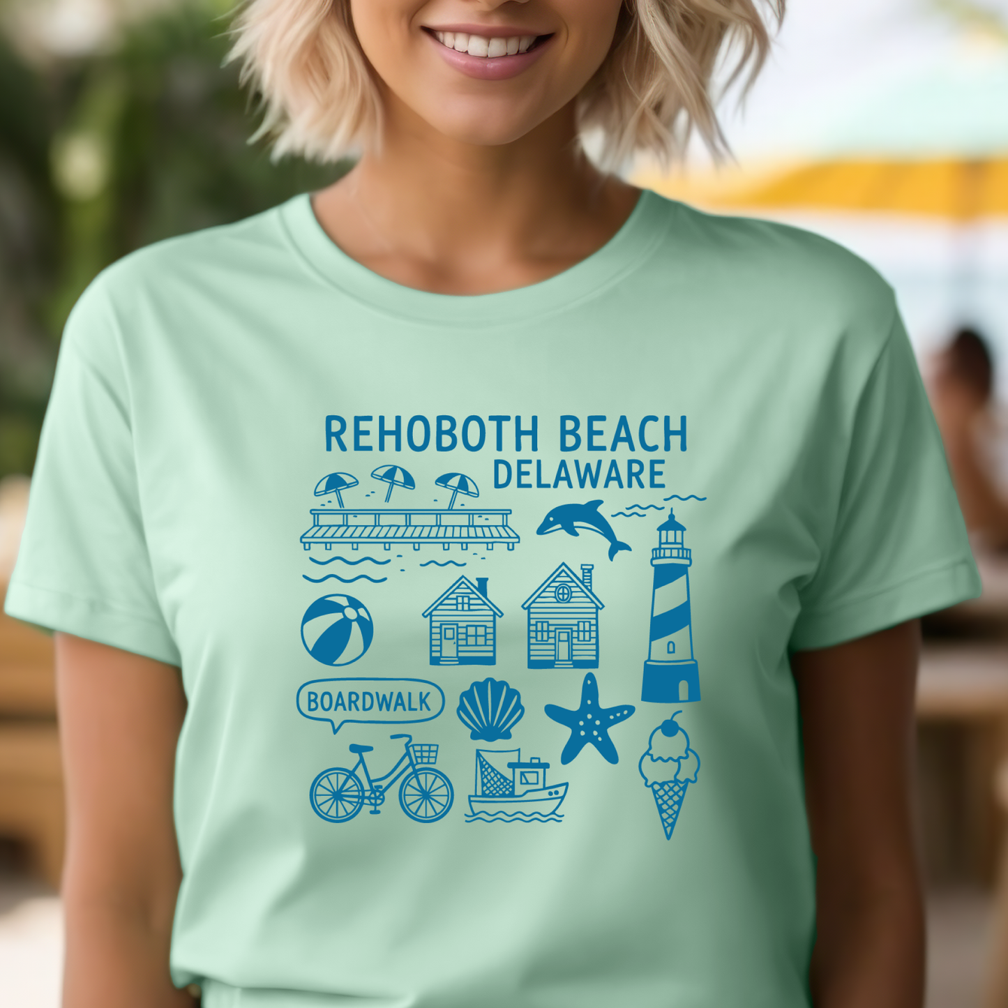 Person wearing a light green t-shirt with Rehoboth Beach, Delaware graphics and text.