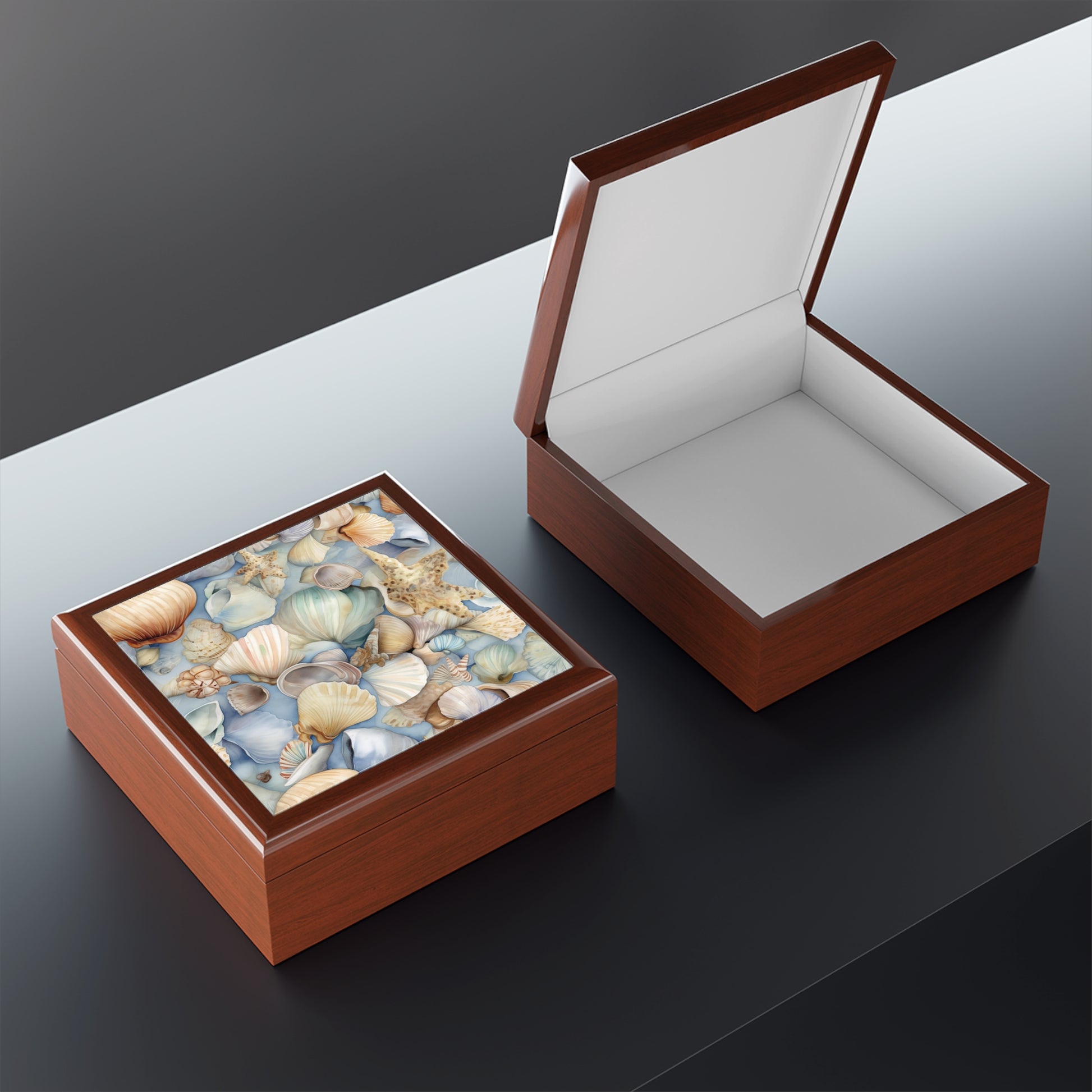 Two Coastal Shells Jewelry Box pieces sit on a reflective surface; one is open, showing its plain white interior, while the other stays closed, highlighting its seashell-patterned decorative lid—ideal for nautical-themed decor and made from premium rubberwood.