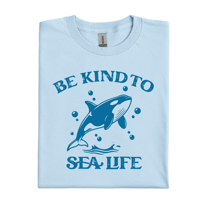 Light blue t-shirt with a whale graphic and text 'Be Kind to Sea Life' on a white background