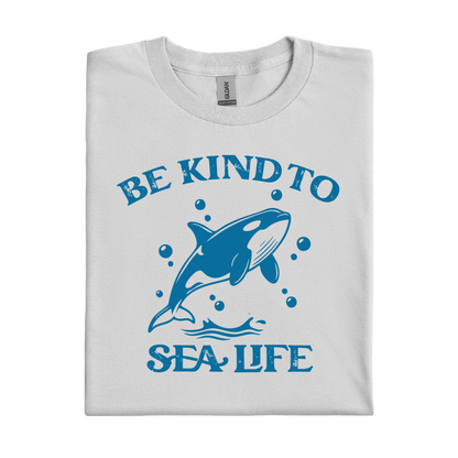 Folded t-shirt with a blue whale graphic and 'Be Kind to Sea Life' text on a white background