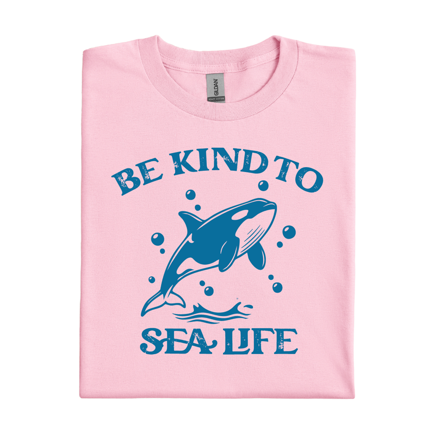 Pink t-shirt with blue orca and text 'Be Kind to Sea Life' on a white background