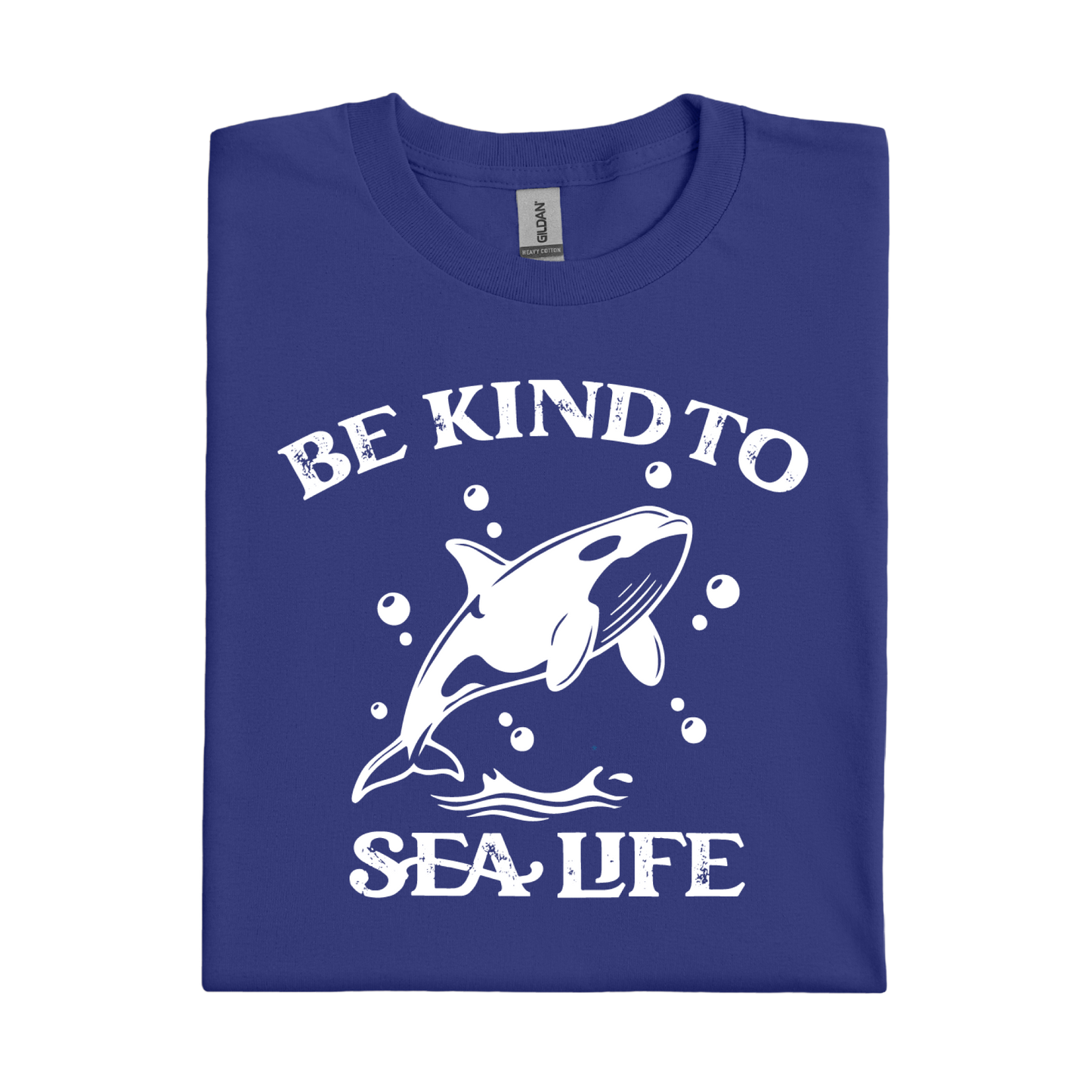 Folded cobalt blue t-shirt with white graphic of a whale and text 'Be Kind to Sea Life' on a white background