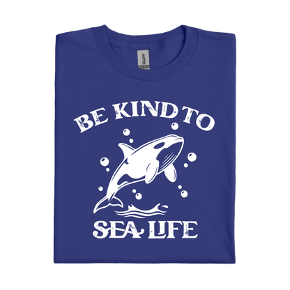 Folded cobalt blue t-shirt with white graphic of a whale and text 'Be Kind to Sea Life' on a white background