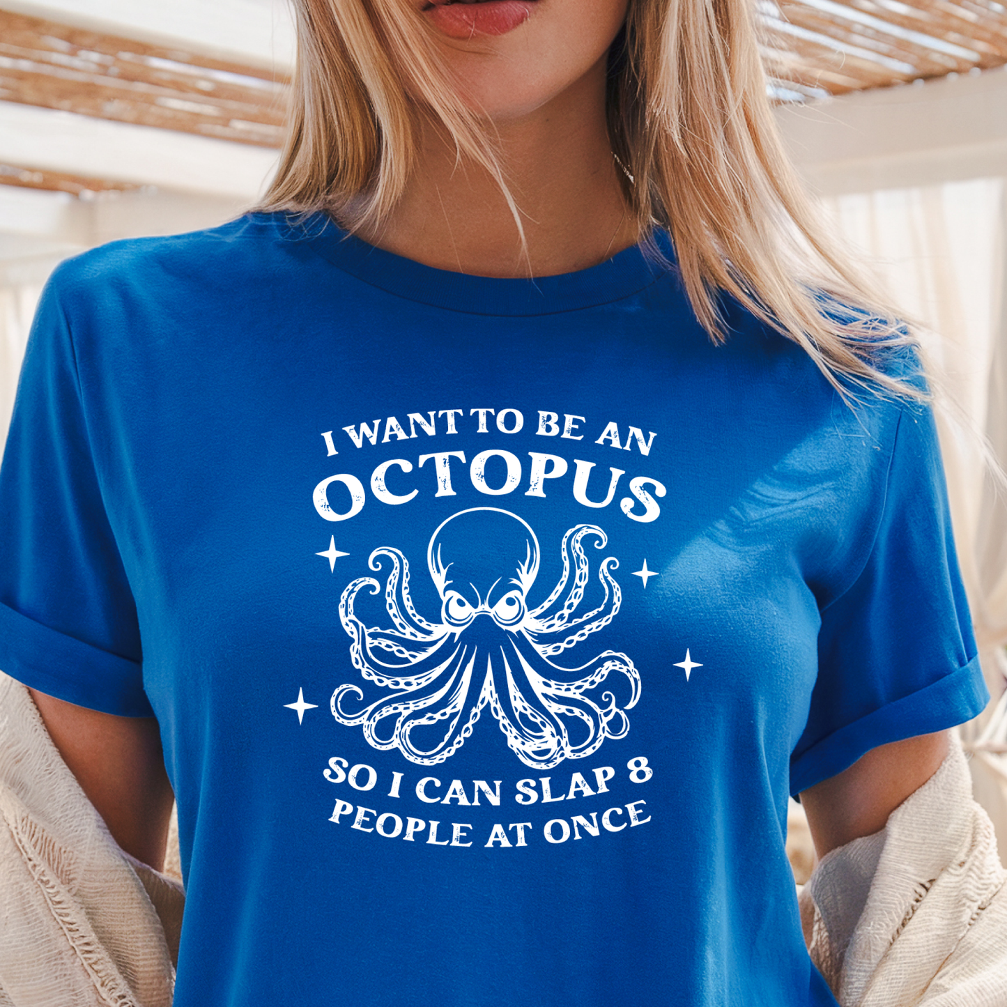 Person wearing a royal blue t-shirt with an octopus graphic and text.