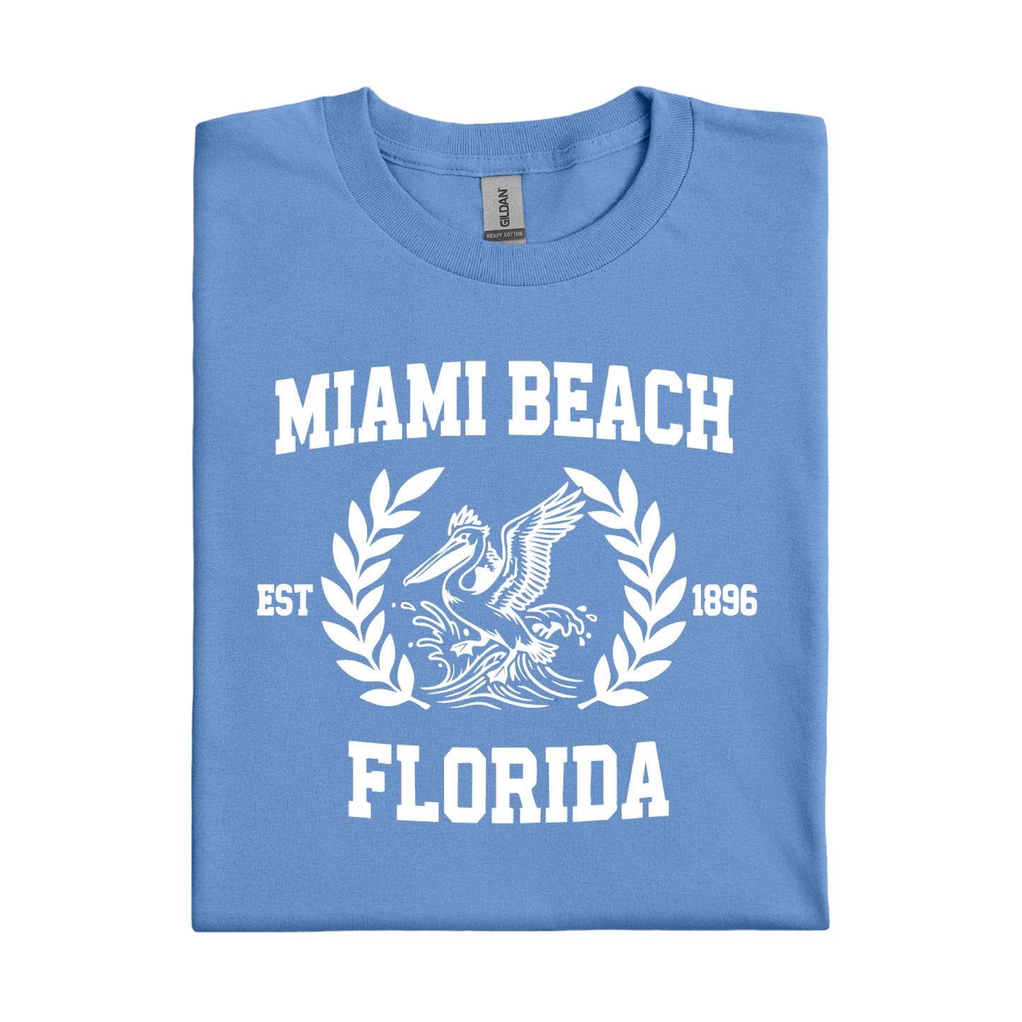 Folded Carolina blue t-shirt with 'Miami Beach Florida' text and pelican design on a white background