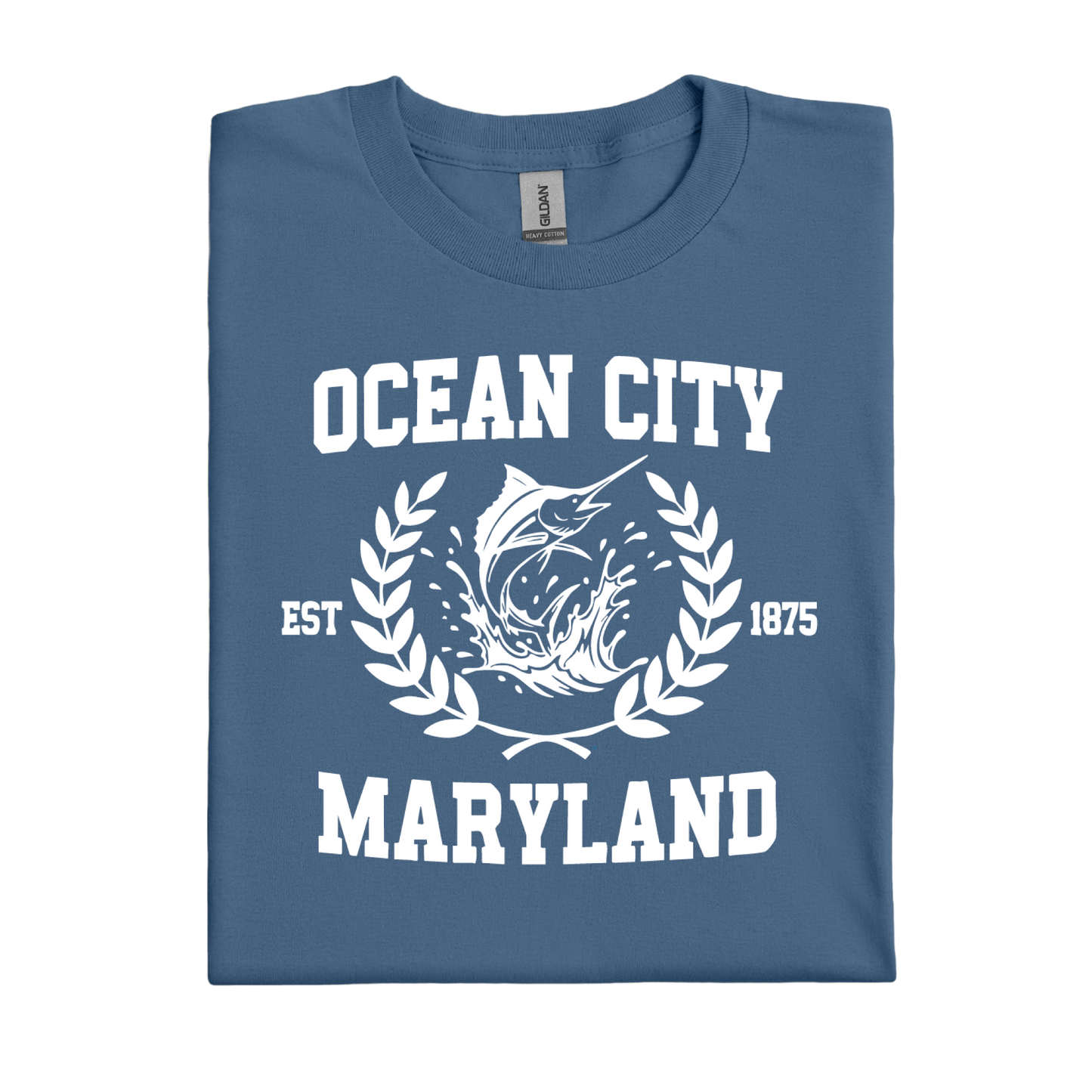 Folded indigo blue t-shirt with 'Ocean City, Maryland' text and fish graphic on a white background
