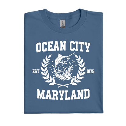 Folded indigo blue t-shirt with 'Ocean City, Maryland' text and fish graphic on a white background