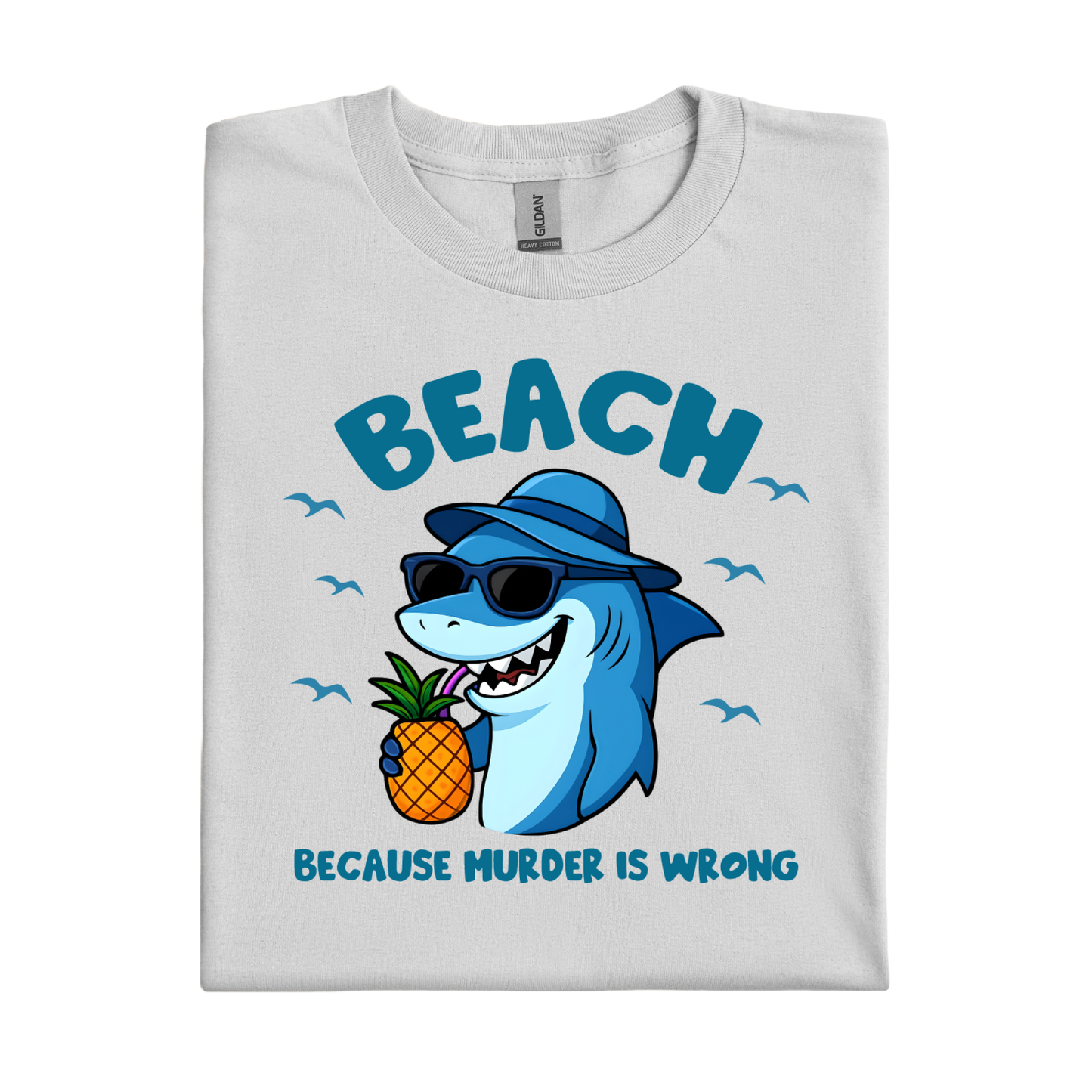 Folded t-shirt with a shark holding a pineapple and text on a white background