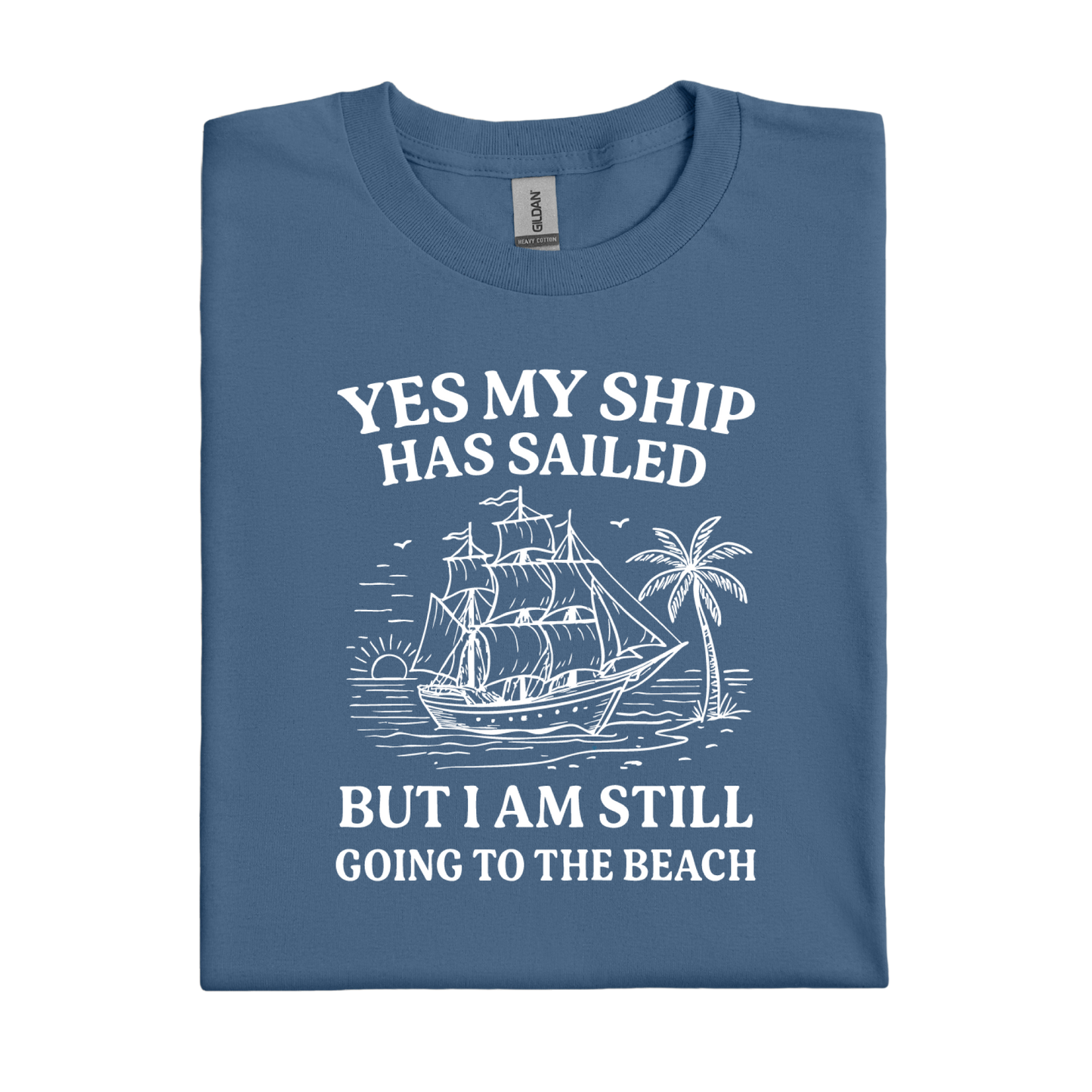 Folded indigo blue t-shirt with a ship and beach graphic and text on a white background