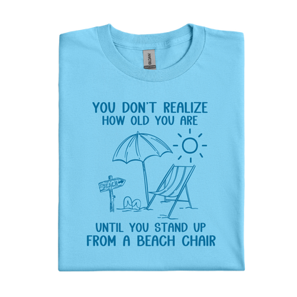 Sky blue t-shirt with beach graphic and text on a white background