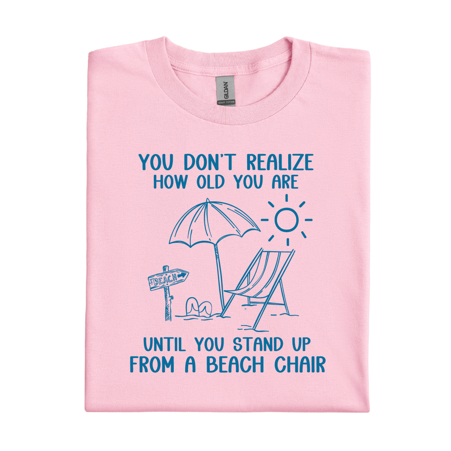 Pink t-shirt with beach-themed design and text on a white background