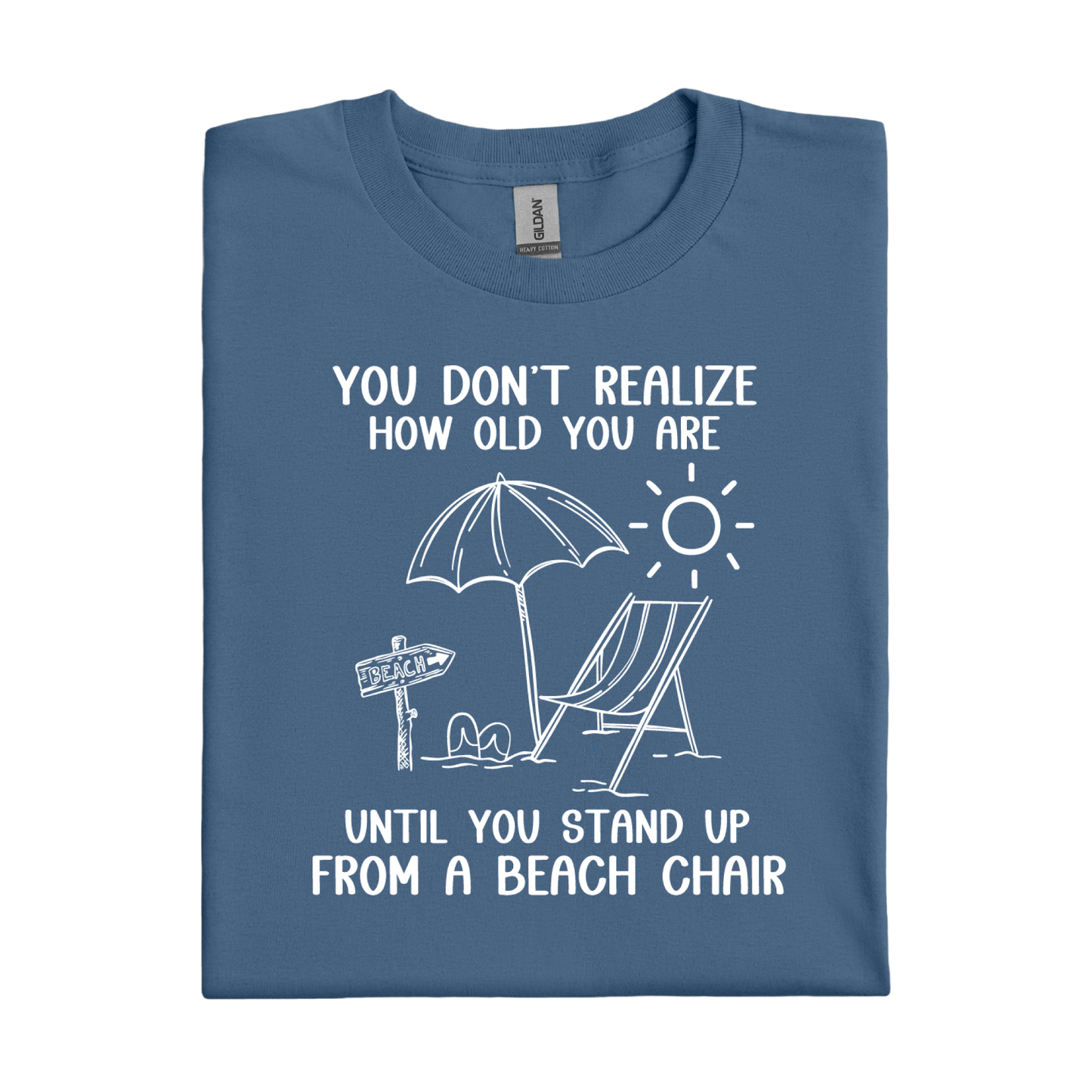 Folded indigo blue t-shirt with beach-themed graphic and text on a white background