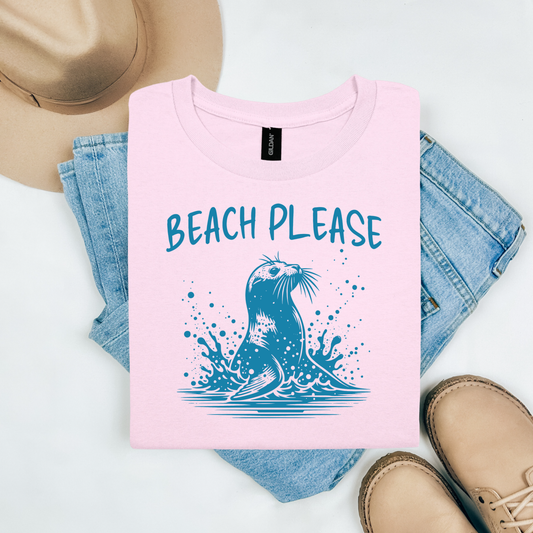 Gildan 5000 "Beach Please" t shirt with a beach seal jumping out of water graphics in one color graphics. Picture on a flay lay mockup with pair of blue jeans, brown shoes and a hat accessory.