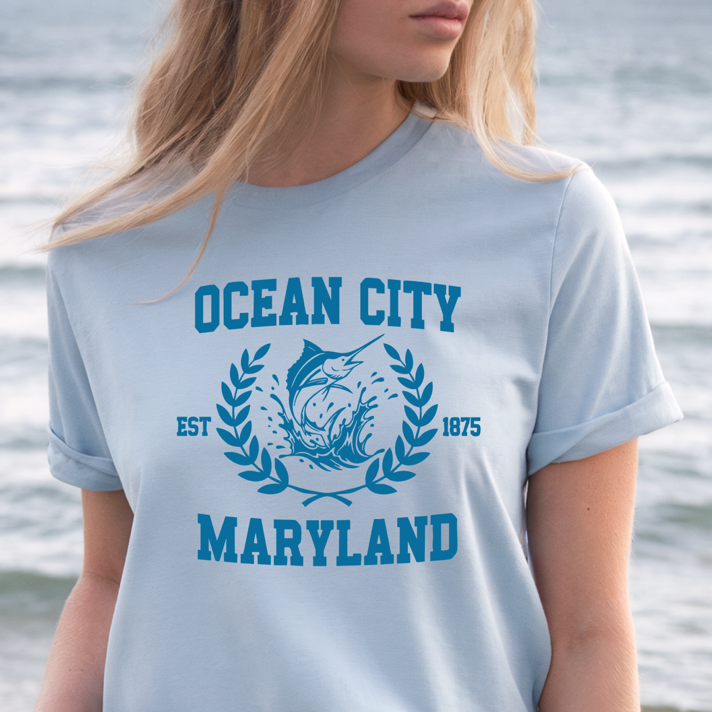 Person wearing a light blue t-shirt with 'Ocean City, Maryland' text and graphic.