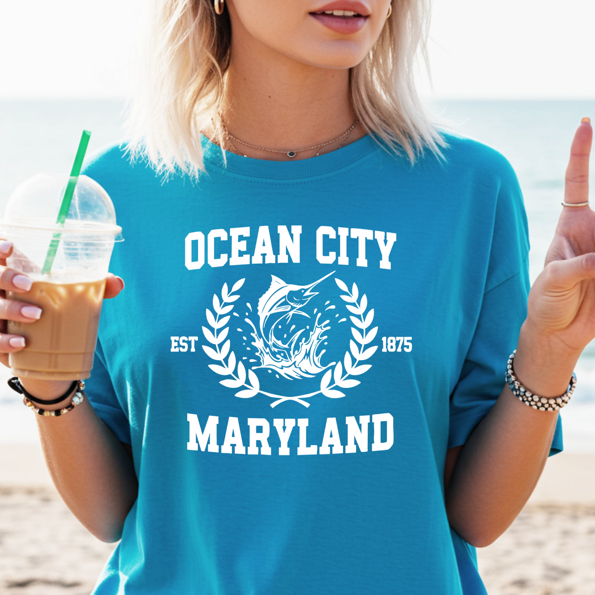 Person wearing a sapphire blue 'Ocean City, Maryland' t-shirt on a beach.