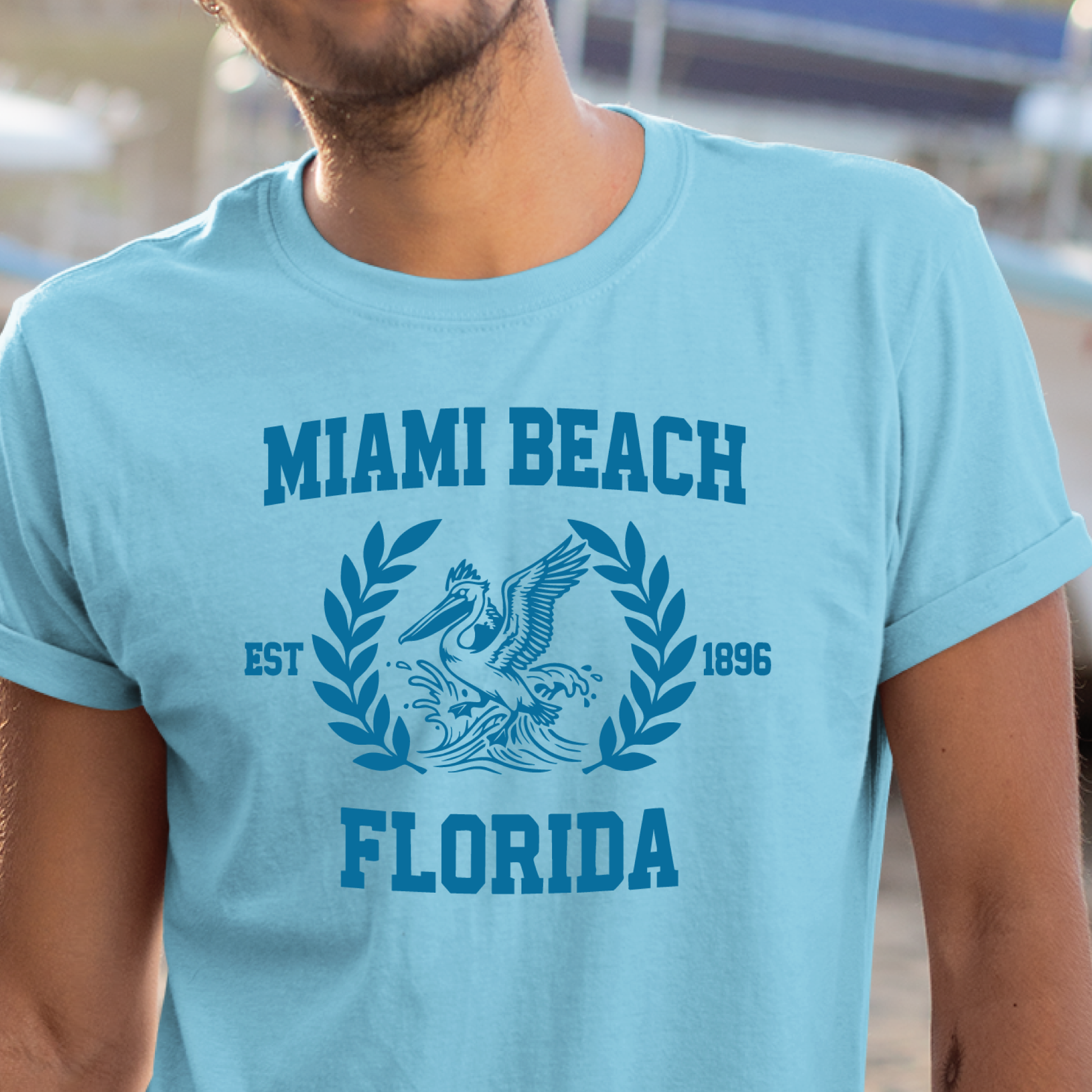 Person wearing a light blue t-shirt with 'Miami Beach, Florida' text and graphic.