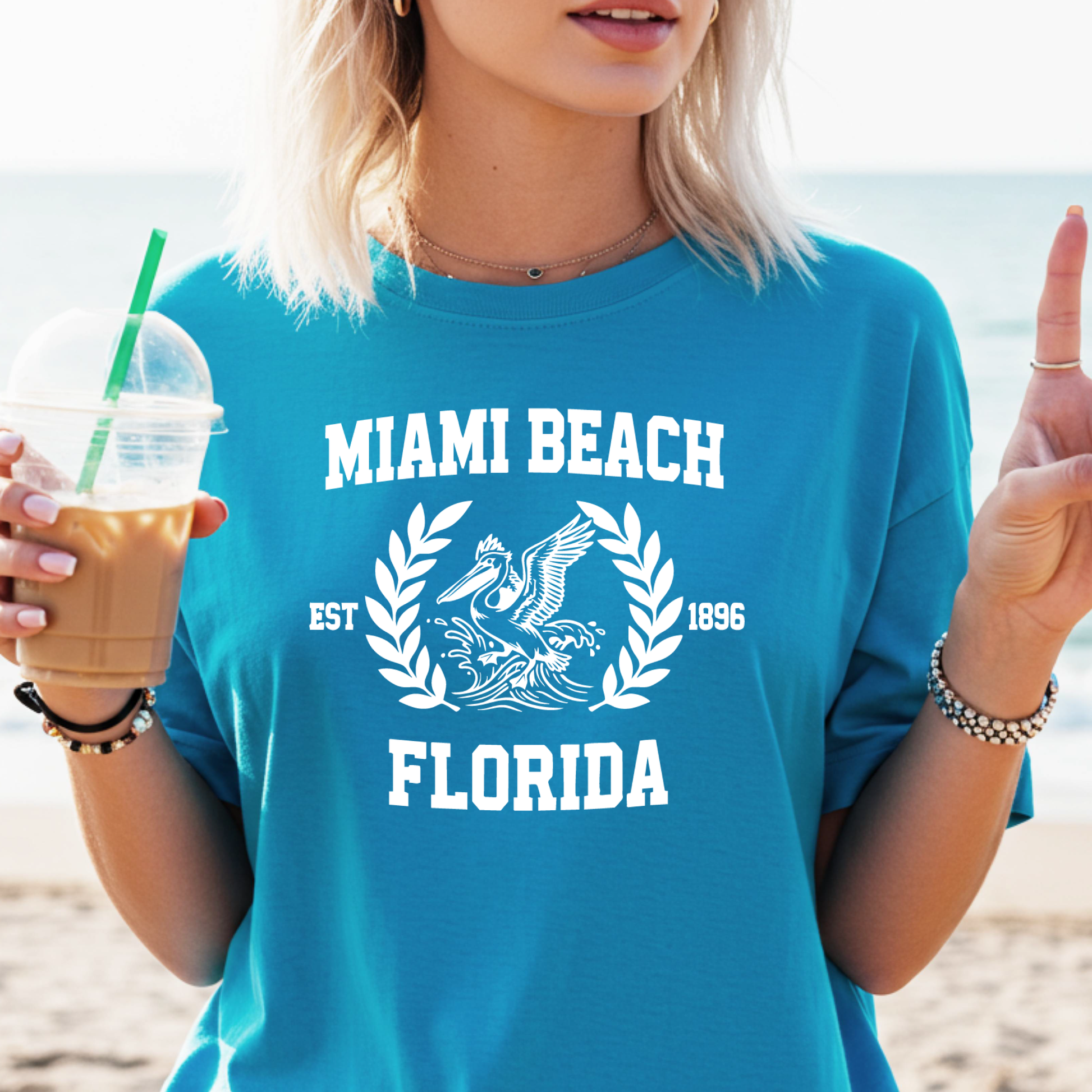 Person wearing a blue 'Miami Beach Florida' t-shirt on a beach.