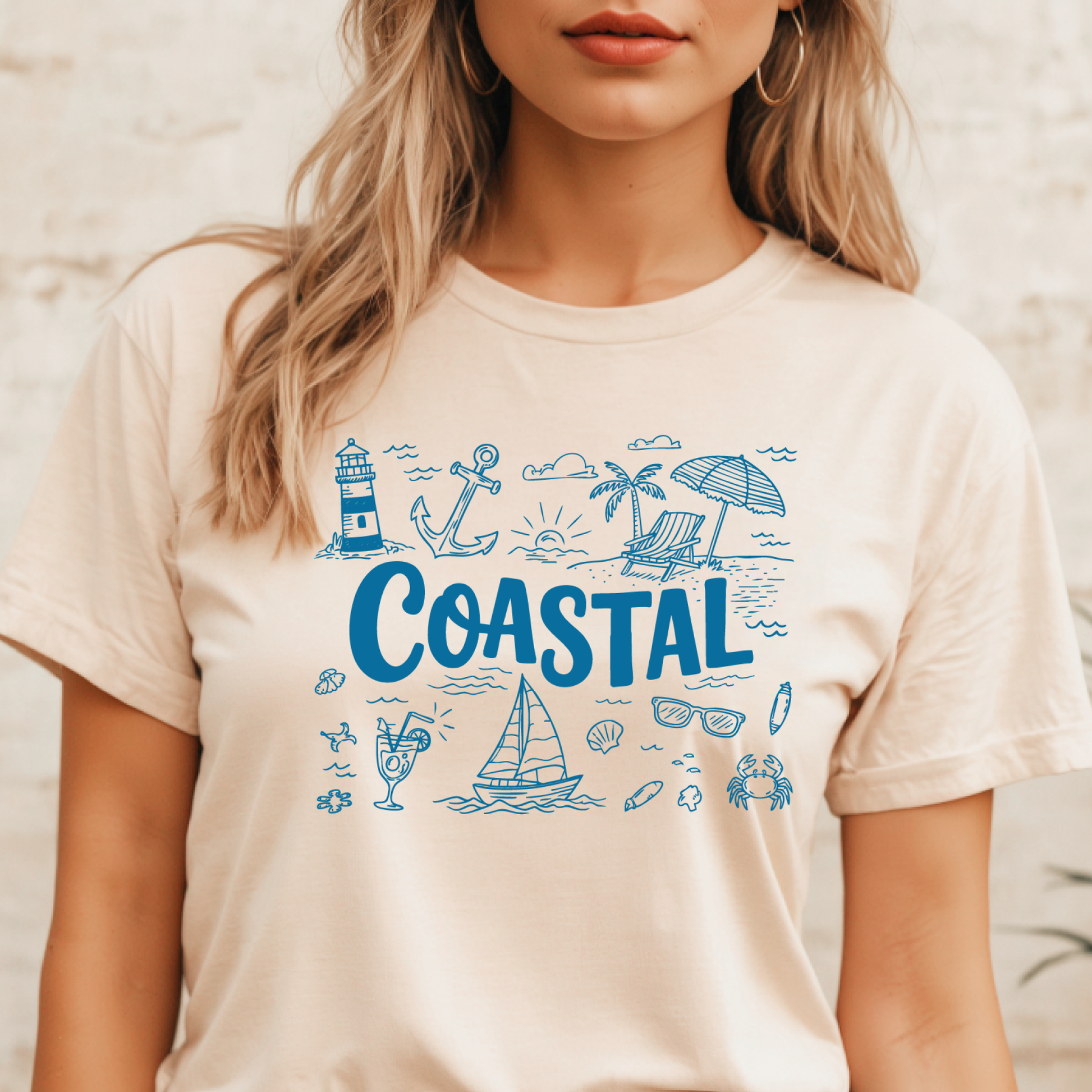 Person wearing a natural colored t-shirt with blue coastal graphics and text.