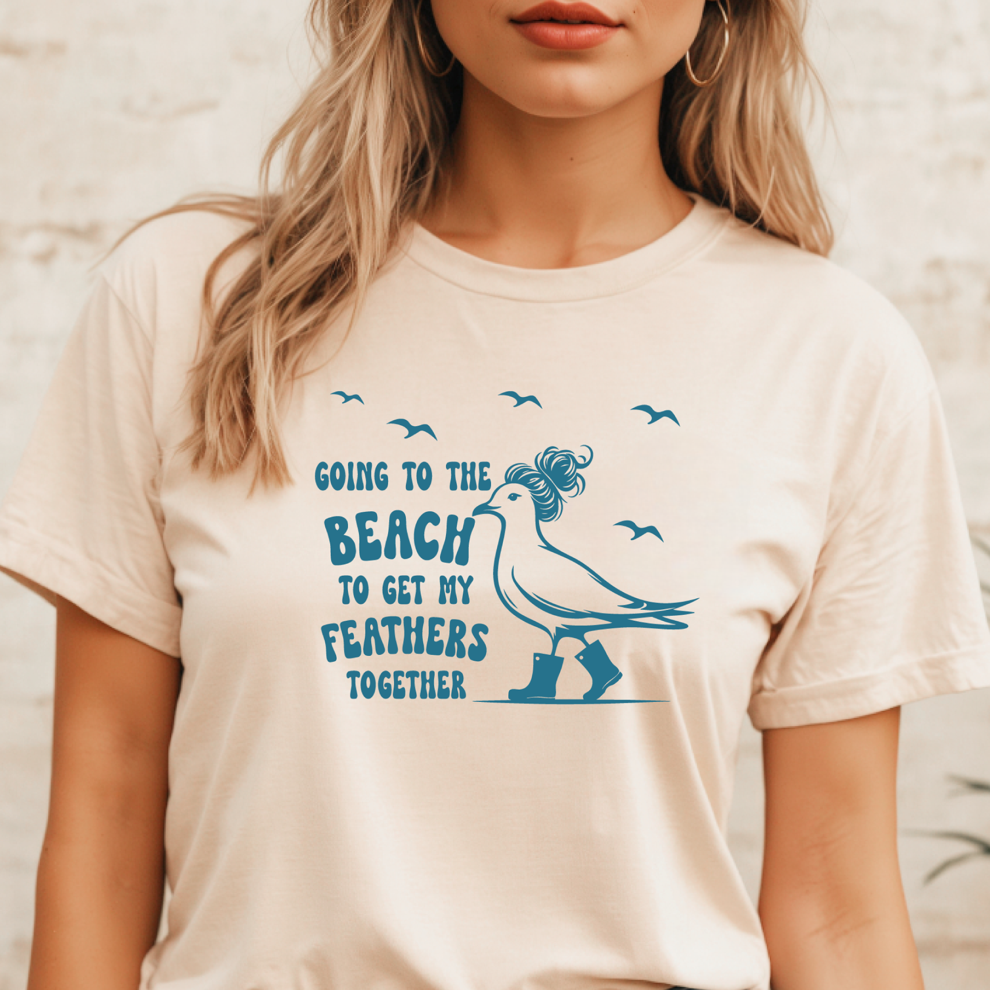 Person wearing a t-shirt with a blue graphic and text on a beige background