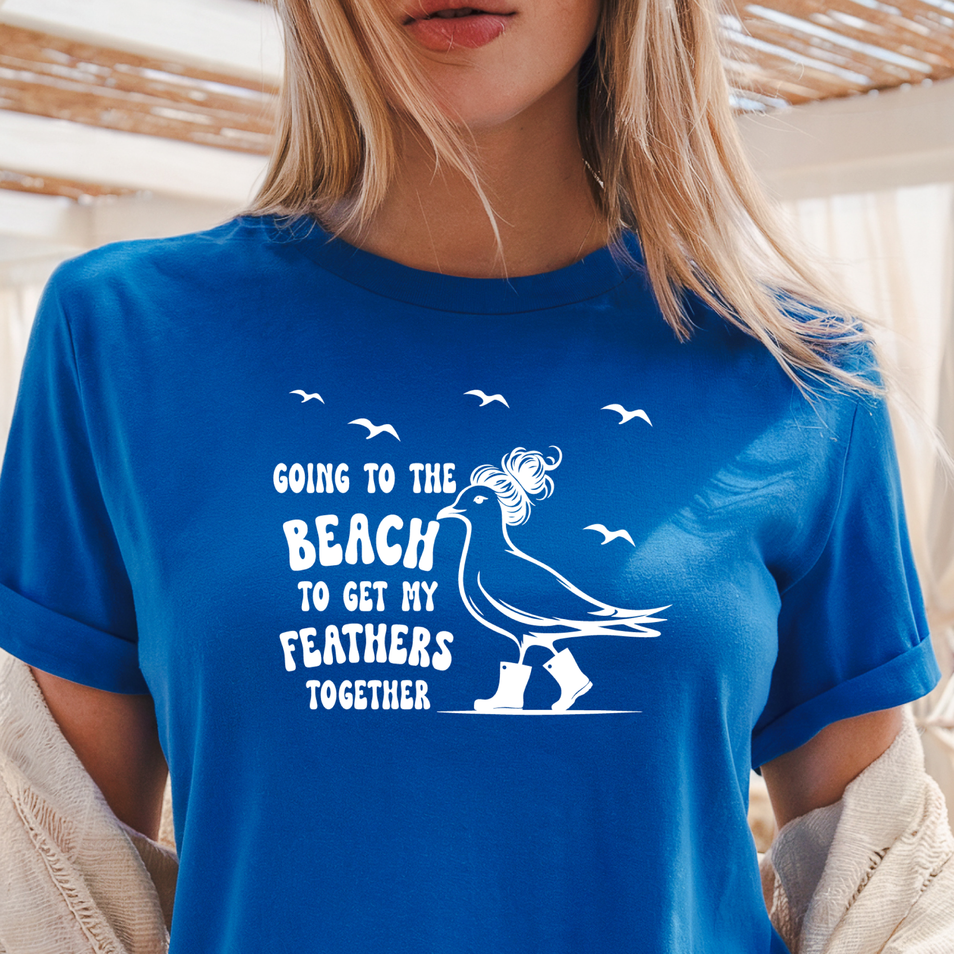Person wearing a royal blue t-shirt with a graphic and text about going to the beach.