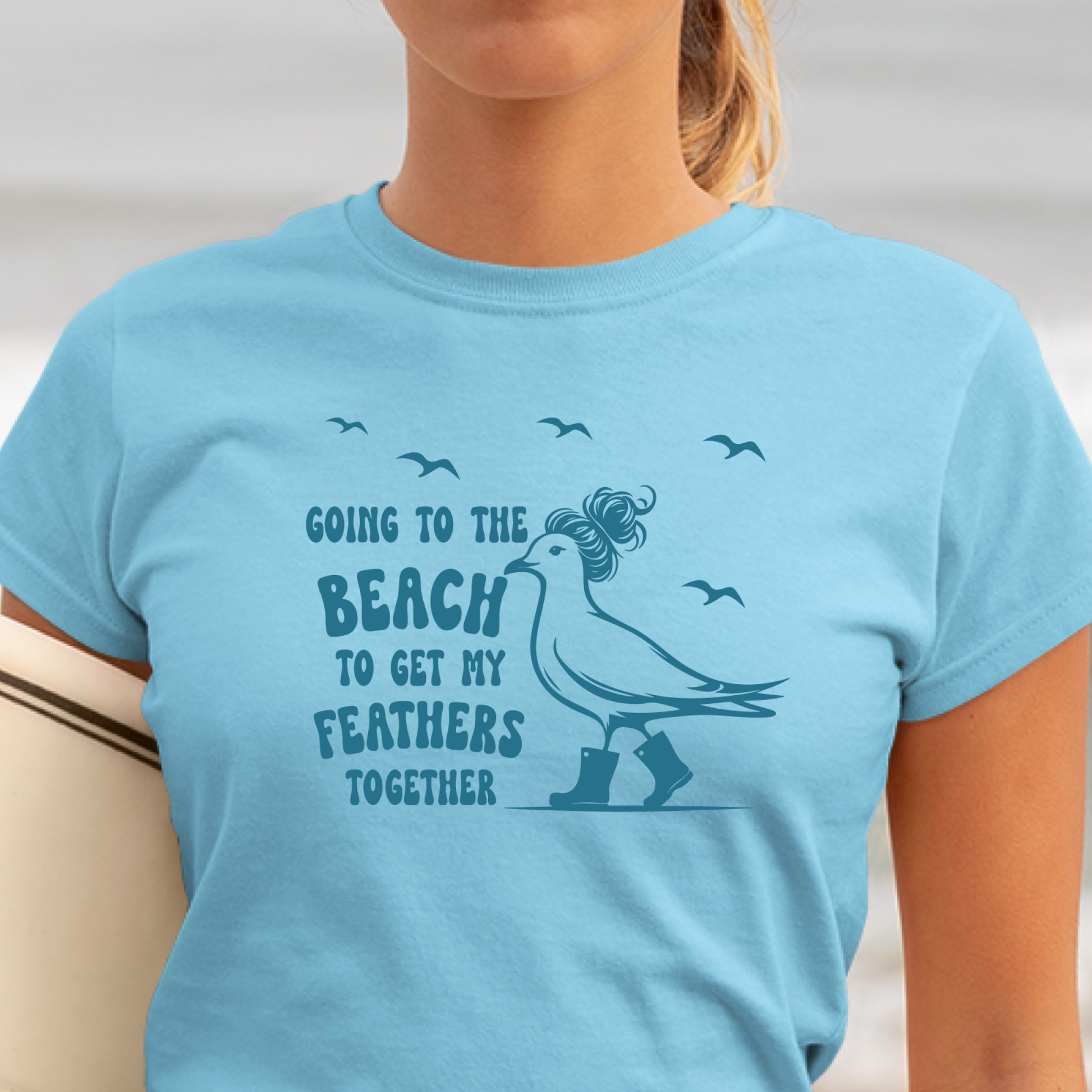 Sky blue t-shirt with a graphic of a bird and text, worn by a person.