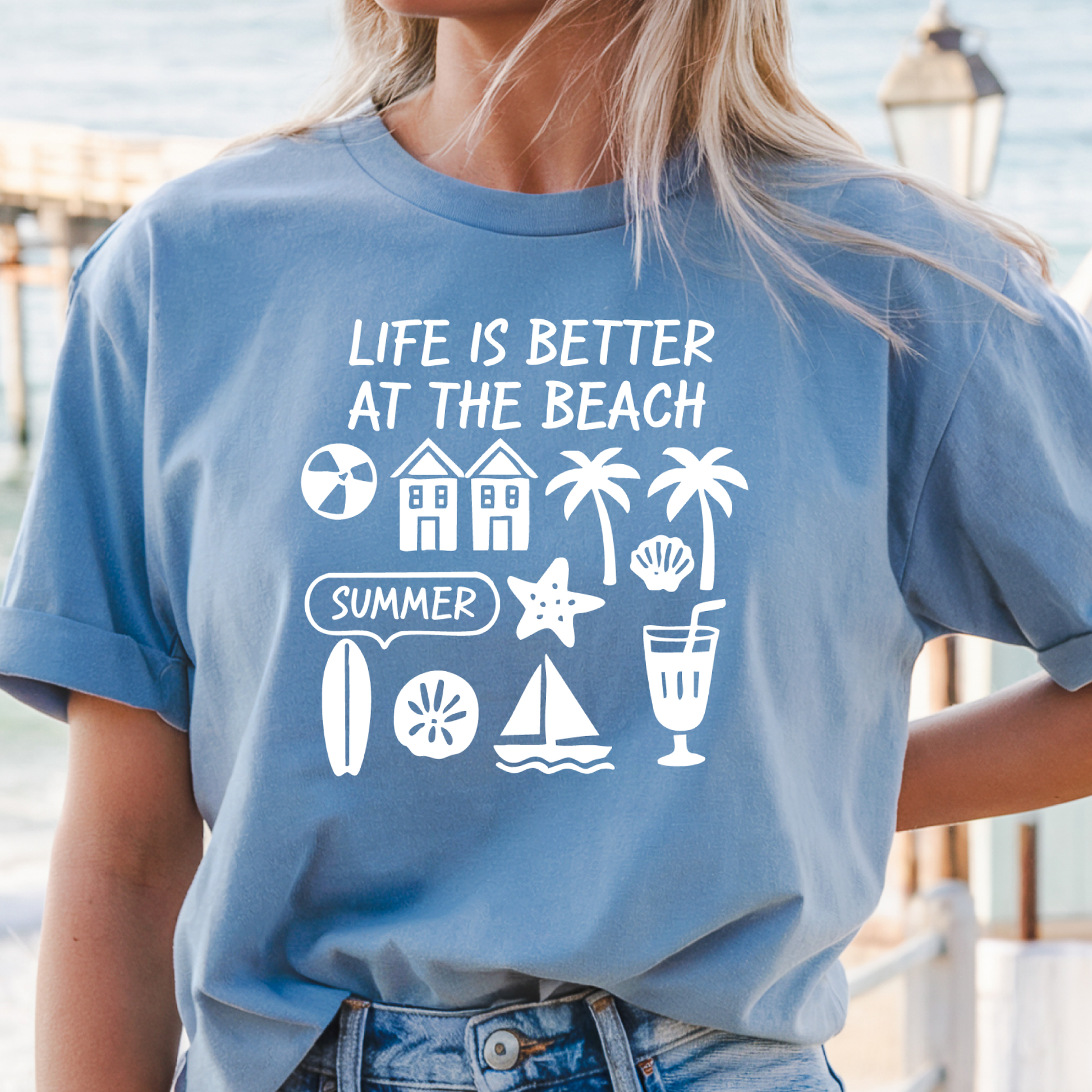 Person wearing a z=Carolina blue t-shirt with beach-themed graphics and text.
