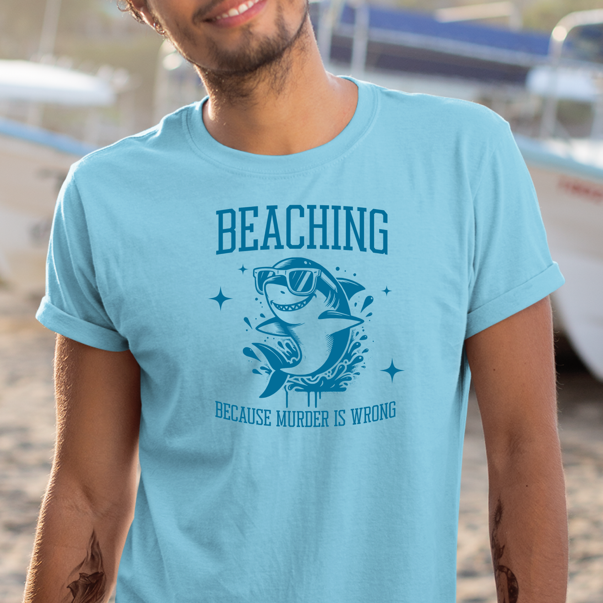 Gildan 5000 "Beaching Because Murder Is Wrong" t shirt with a funny shark with sunglasses jumping out of water in one color graphics. Picture of a man standing in a ship yard wearing a t shirt.