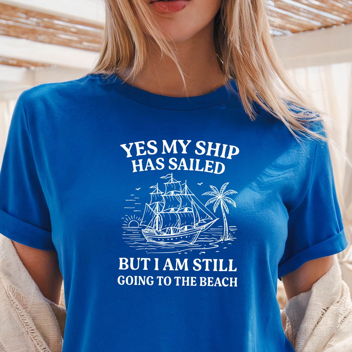 Person wearing a Royal blue t-shirt with a ship graphic and text.