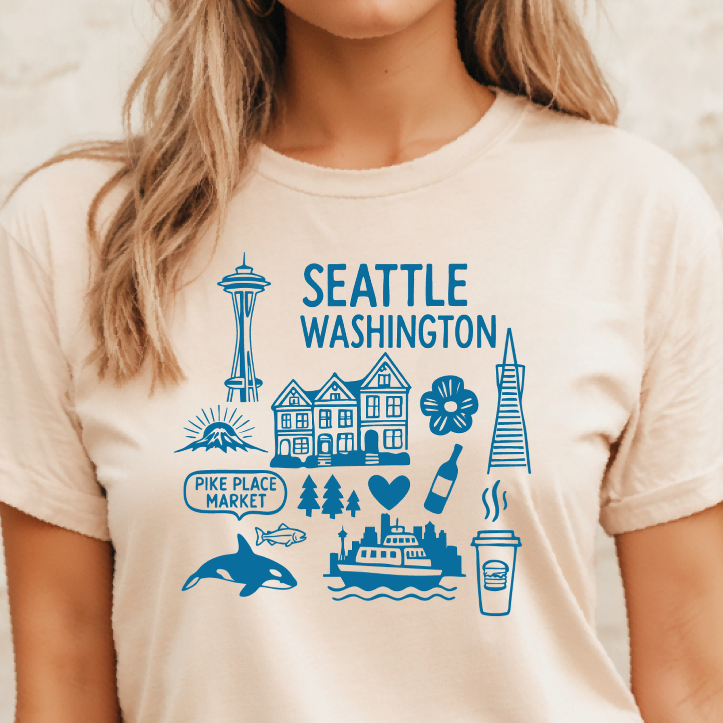 Person wearing a t-shirt with Seattle-themed graphics and text.
