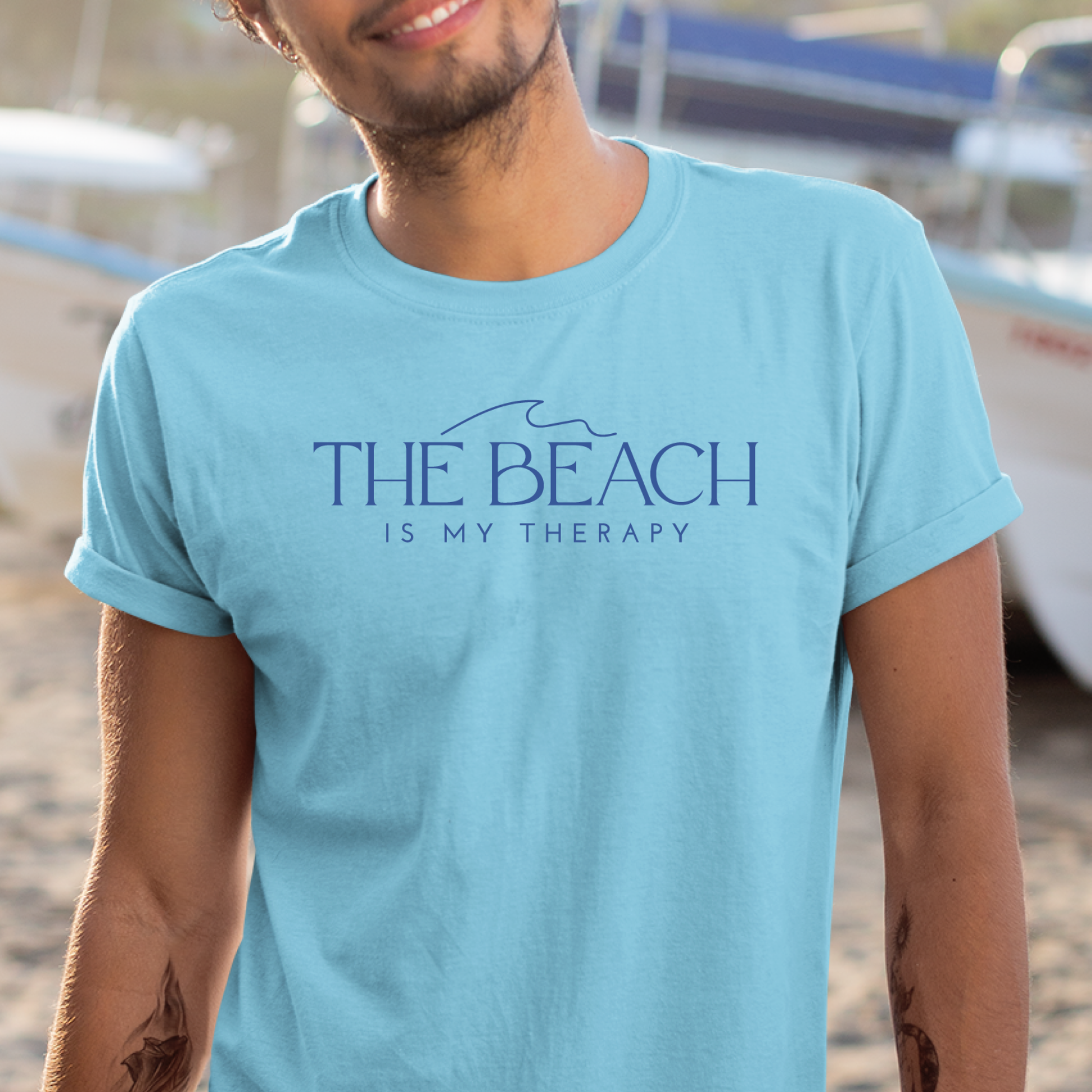 Gildan 5000 "The Beach Is My Therapy" t shirt with a simple wave graphic in one color. Picture of a man standing in a ship yard wearing a t shirt.
