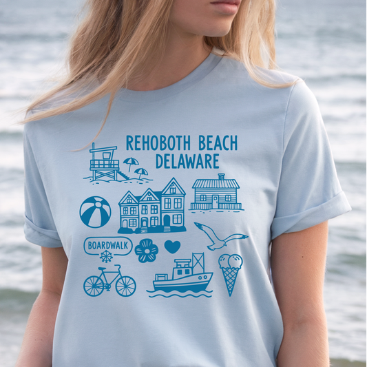 Person wearing a light blue t-shirt with Rehoboth Beach, Delaware graphics and text.
