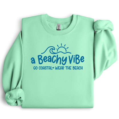 Mint green sweatshirt with 'a Beachy Vibe' text and graphics on a white background