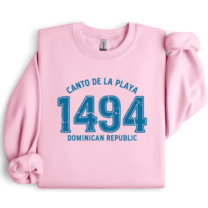 Gildan sweatshirt with “Canto De La Playa 1494 Dominican Republic” printed in distressed navy text. Vintage beach-inspired crewneck symbolizing Caribbean heritage and coastal charm. Made from soft cotton-poly blend fabric for comfort and style, ideal for beach lovers and travelers who adore Dominican culture. Cozy, sustainable, and perfect for casual wear or tropical getaways.