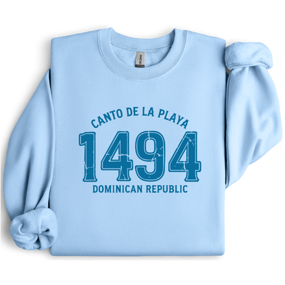 Gildan sweatshirt with “Canto De La Playa 1494 Dominican Republic” printed in distressed navy text. Vintage beach-inspired crewneck symbolizing Caribbean heritage and coastal charm. Made from soft cotton-poly blend fabric for comfort and style, ideal for beach lovers and travelers who adore Dominican culture. Cozy, sustainable, and perfect for casual wear or tropical getaways.